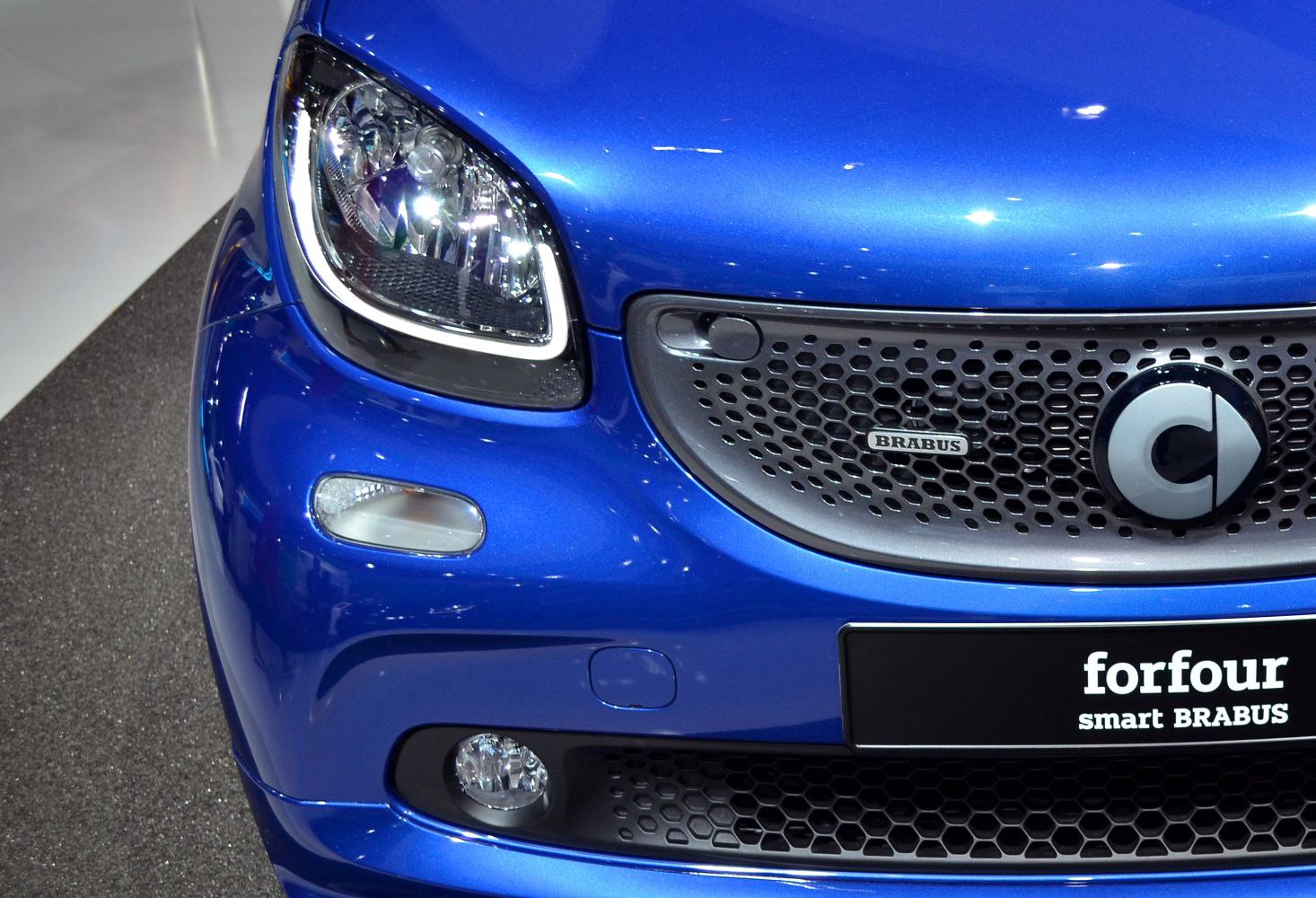 Close-up of front grille, Brabus badge, and headlight on blue vehicle