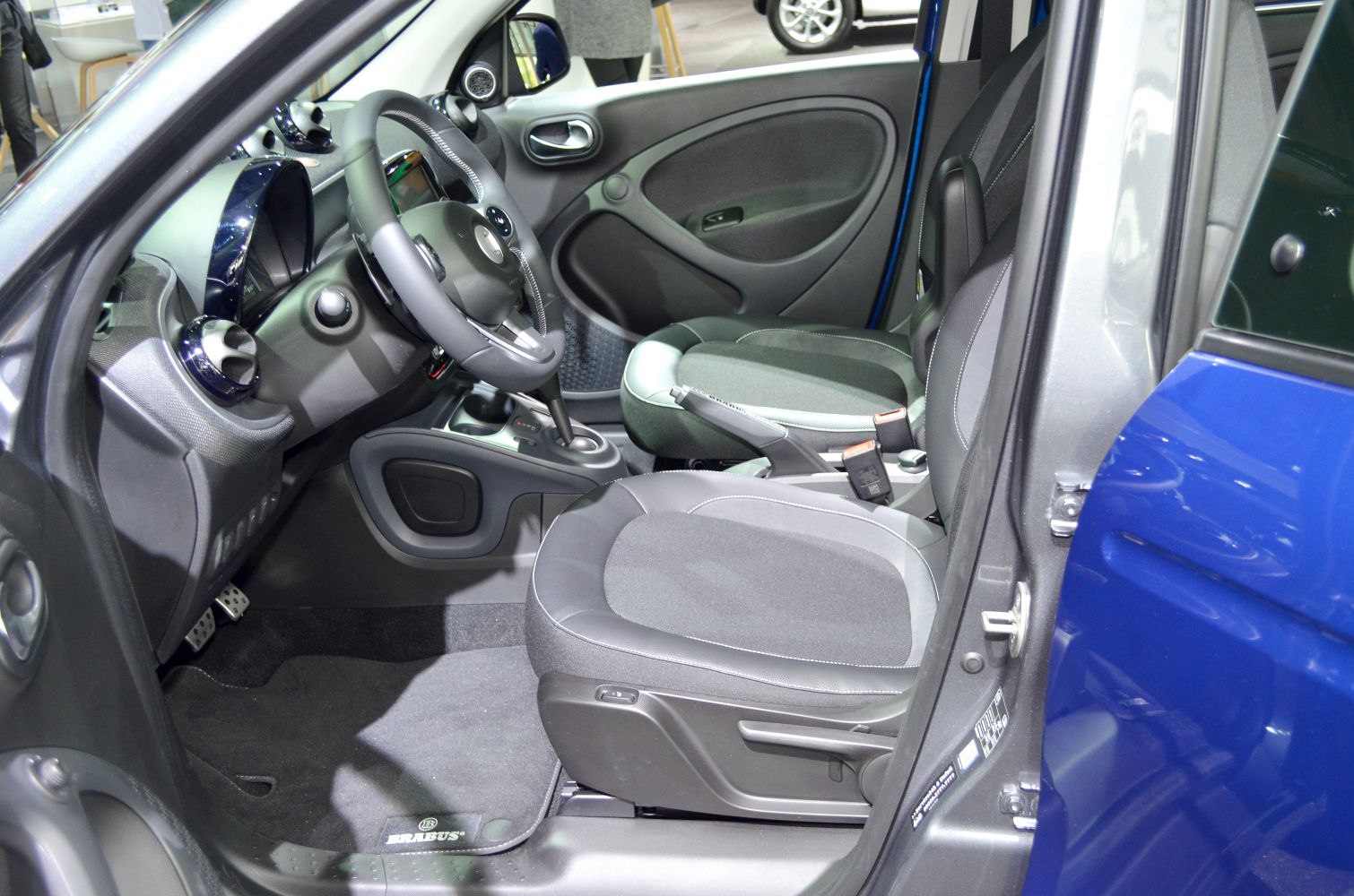 Compact car interior with dashboard, steering wheel, and front seats