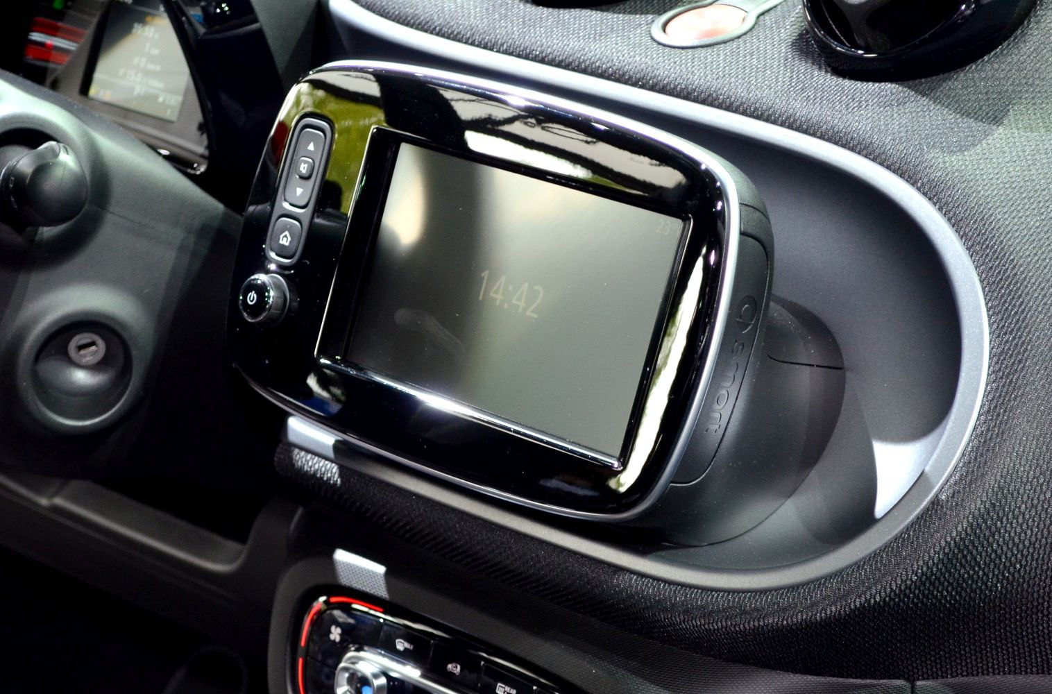 Central infotainment touchscreen with control buttons on vehicle dashboard