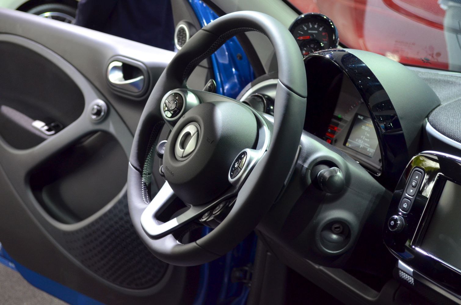 Steering wheel and digital dashboard close-up inside a compact car