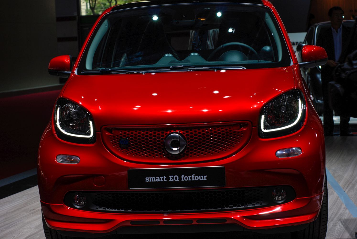Red compact car front with LED headlights and distinctive grille