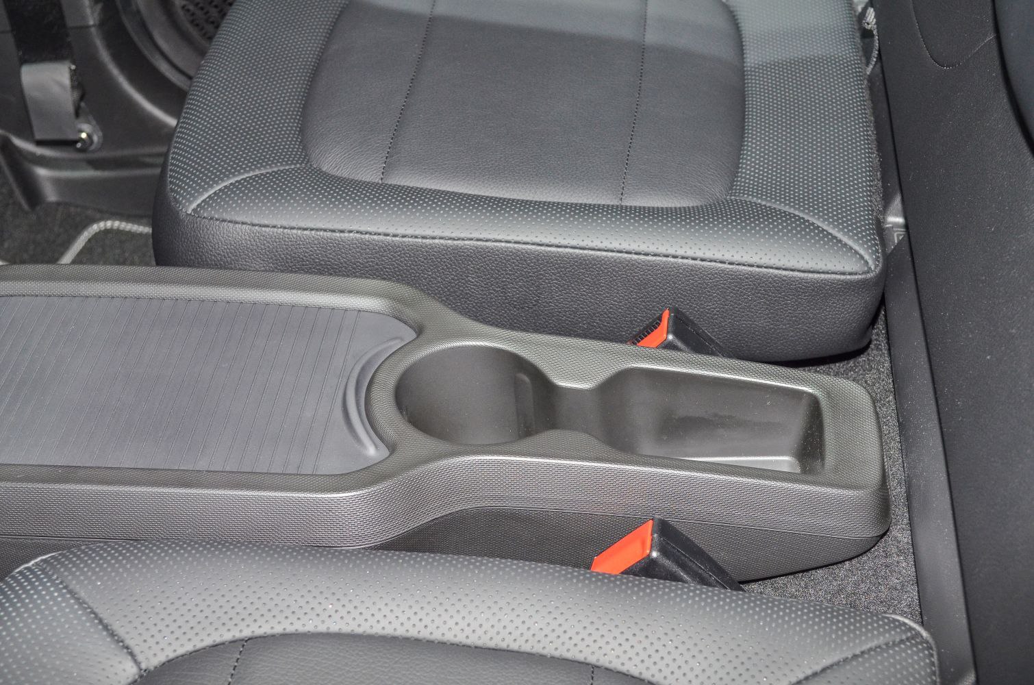 Center console with cup holder and black perforated seats