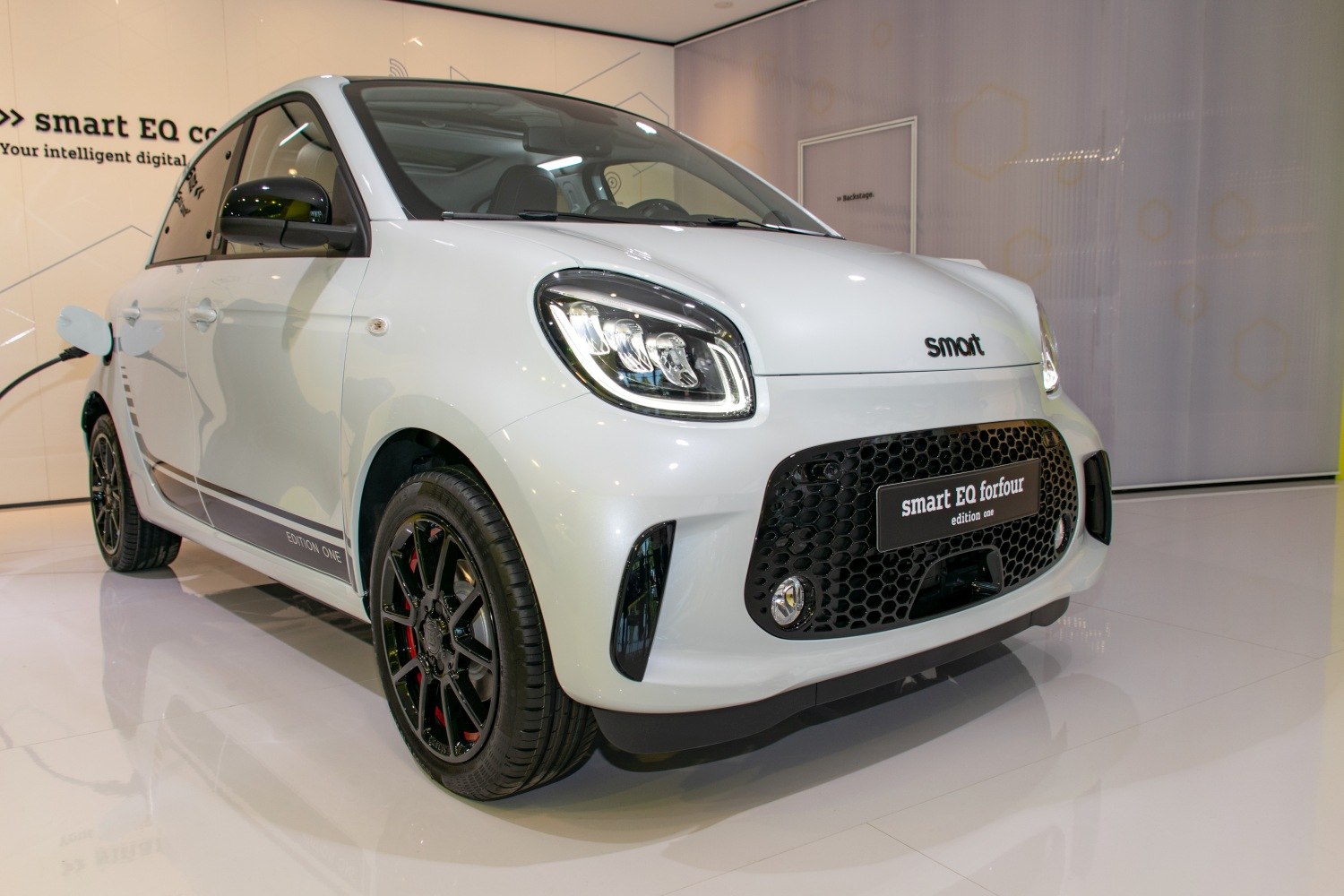 White compact electric hatchback front view with LED headlights and black honeycomb grille