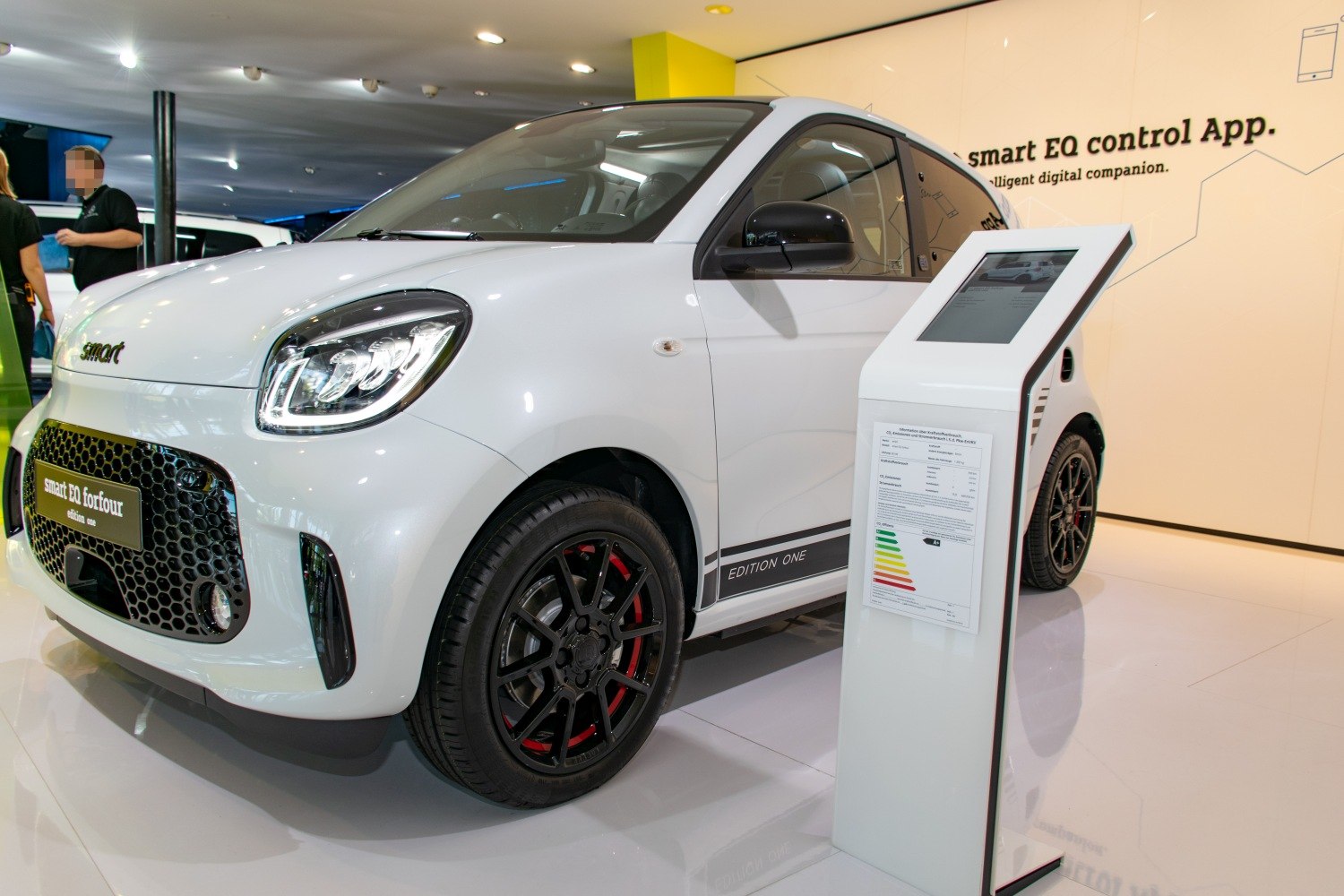 White electric hatchback with black multi-spoke alloy wheels and modern front design