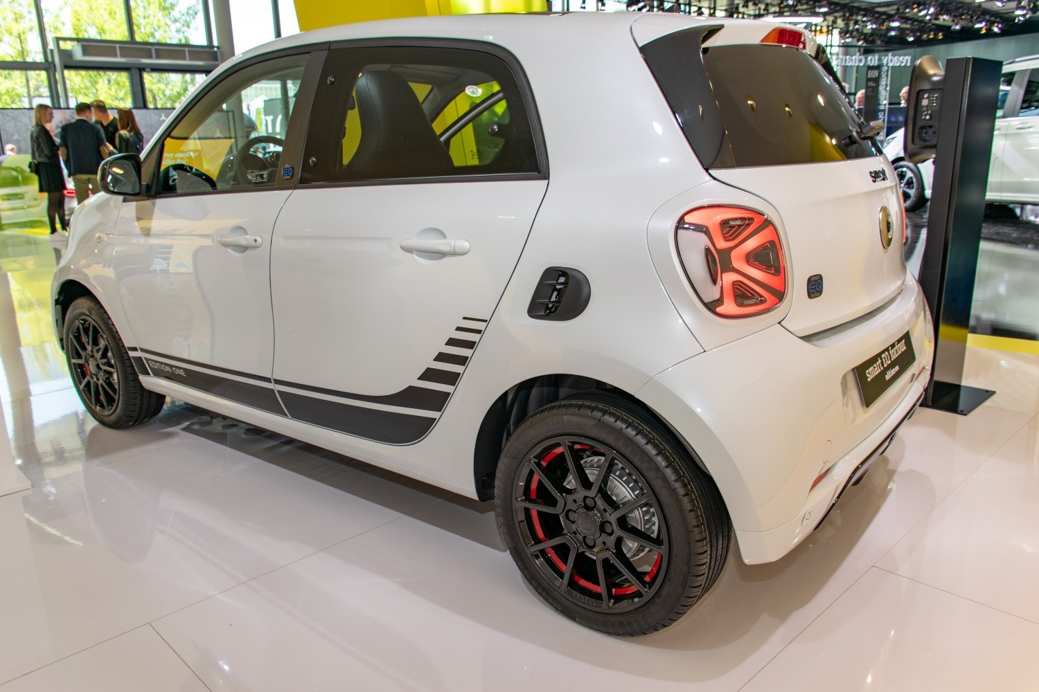 Compact electric hatchback with distinctive tail light and sporty black alloy wheels with red accents