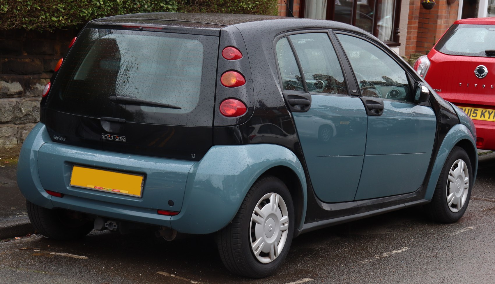 Rear and side view of a compact 4-door hatchback with unique taillights and dual-tone body.