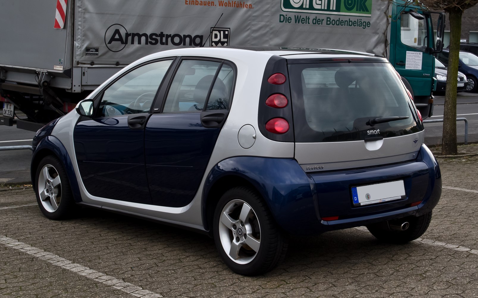 Compact hatchback rear side view with distinct tail lights and alloy wheels.