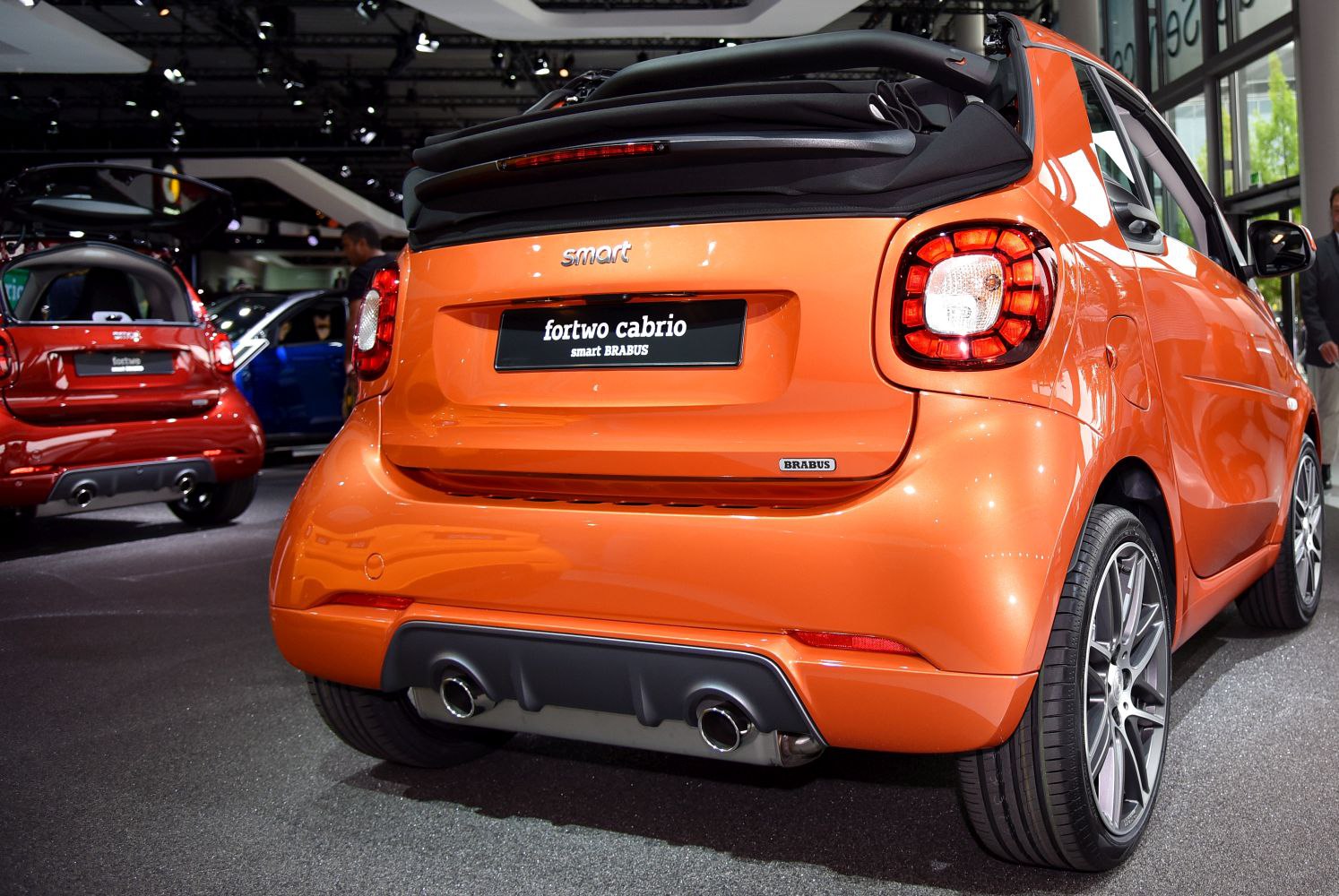 Rear view of orange convertible with dual exhaust and folded soft top