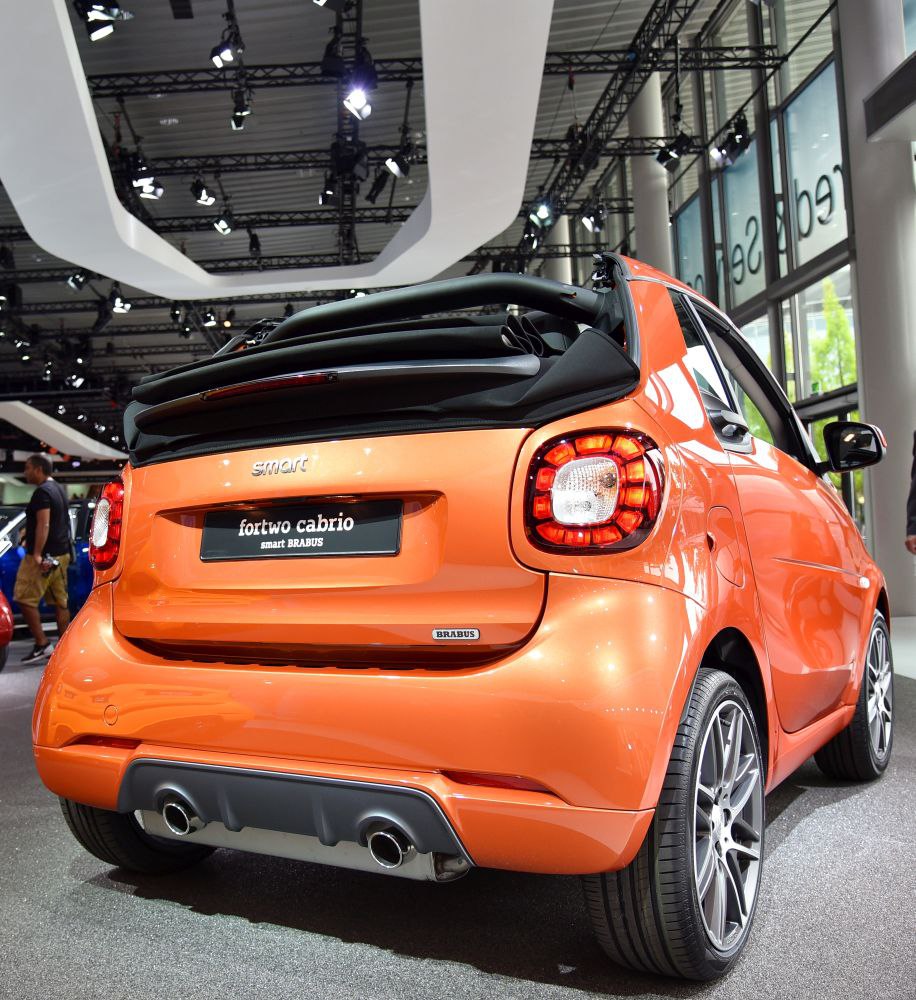 Rear view of orange convertible with LED tail lights and dual exhausts