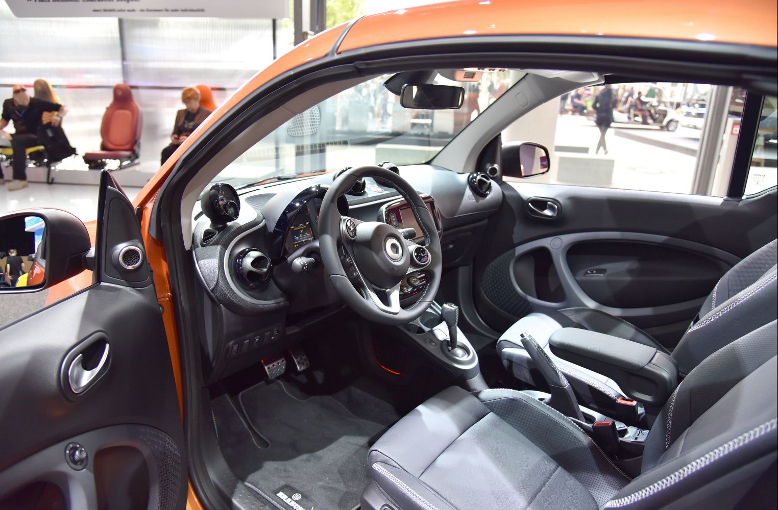 Dashboard, steering wheel, gear shift, and seating in compact car interior