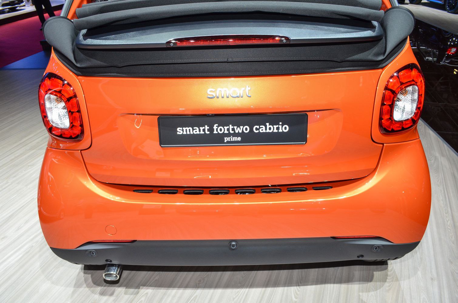 Rear view of orange convertible with distinct taillights and soft top.