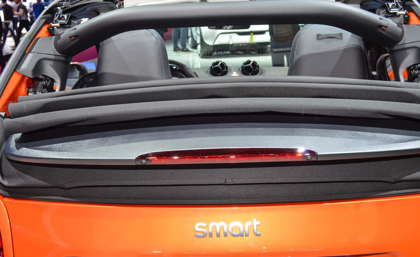 Folded soft-top convertible roof and rear deck with brake light.