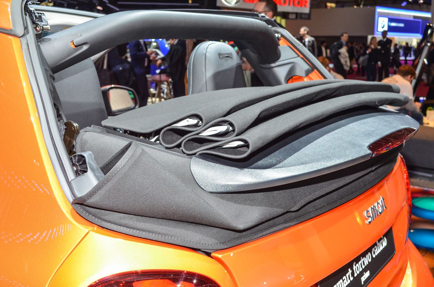 Retractable soft fabric roof folded on a compact convertible.
