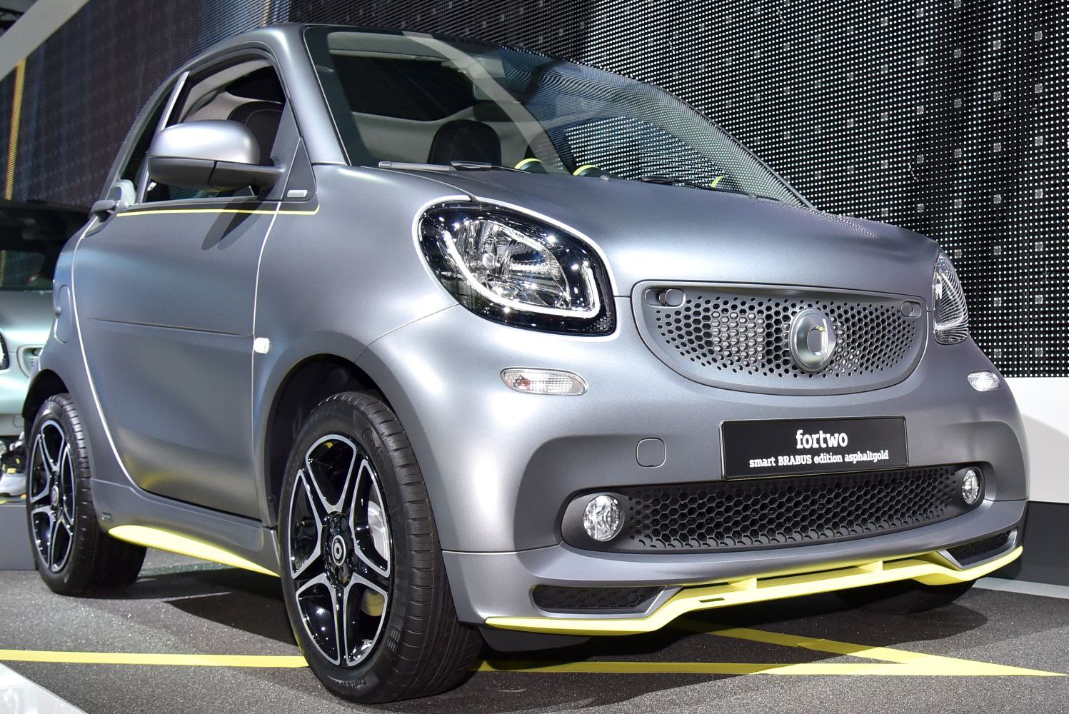 Front and side view of compact car with distinctive grille and sporty wheels