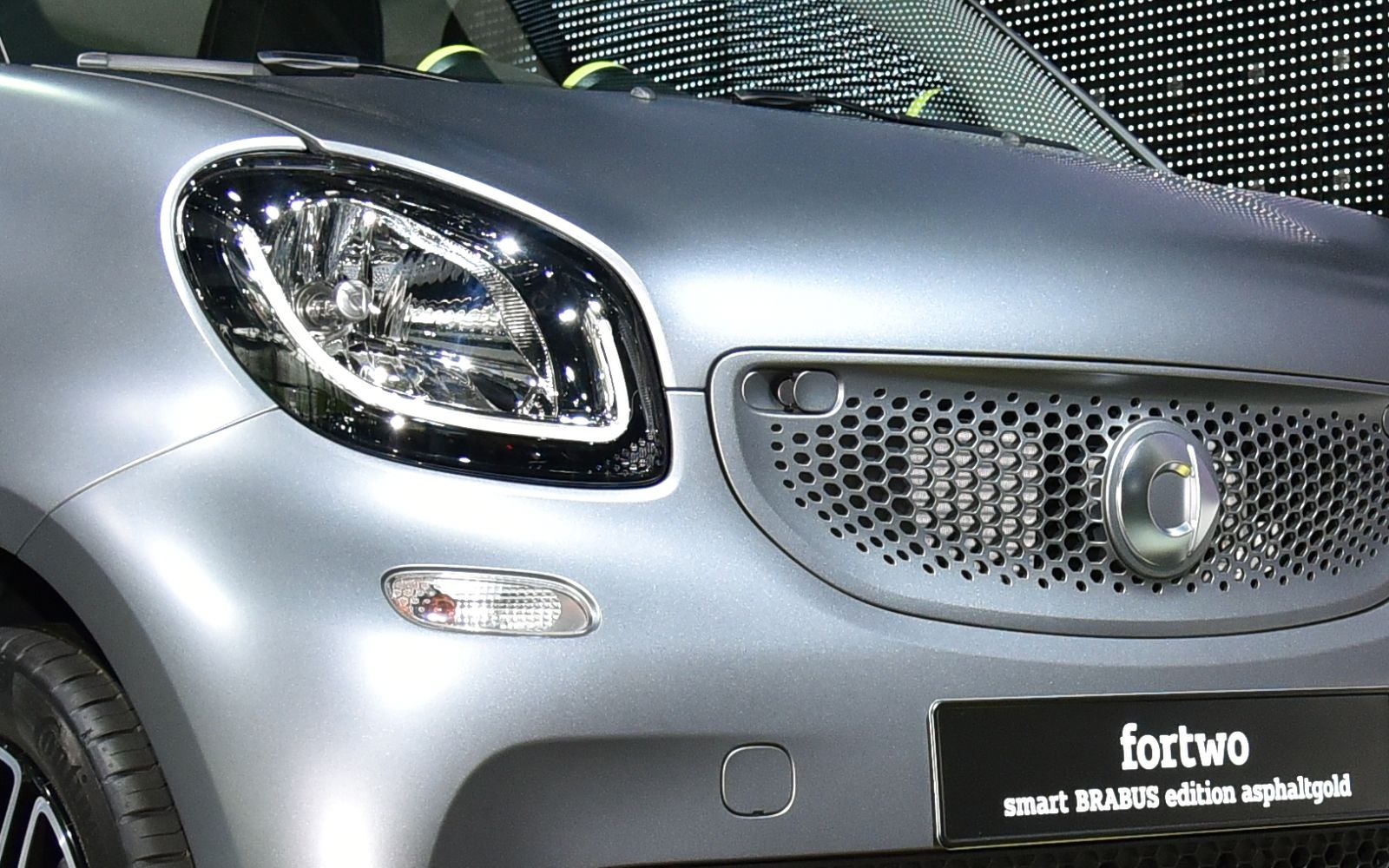 Close-up of front grille with logo and headlight of a compact car