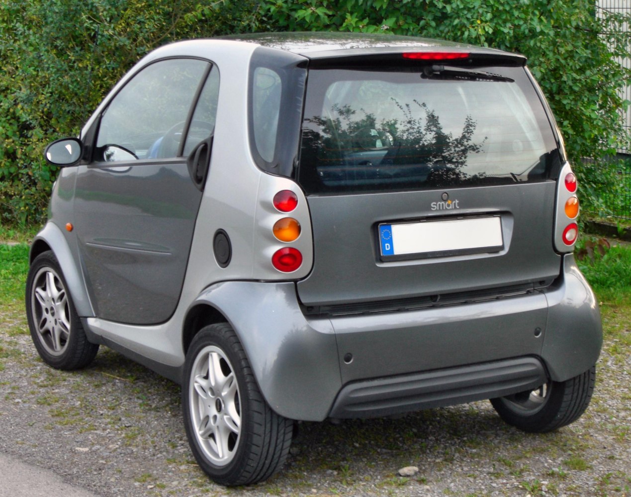 Rear side view of a compact two-door hatchback with distinctive light clusters