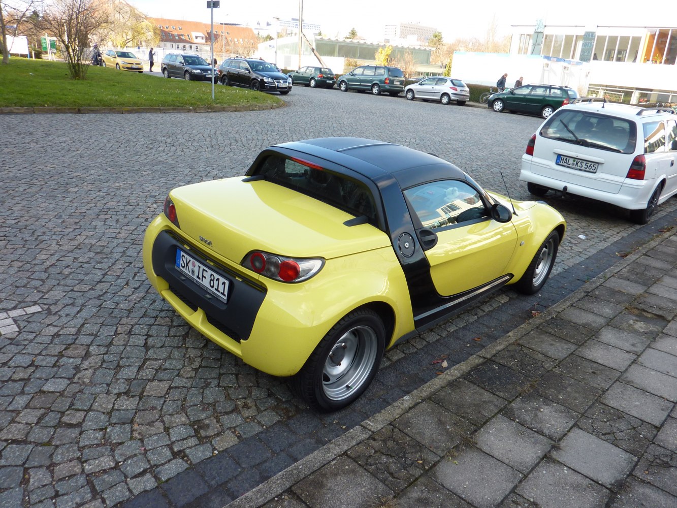 Yellow compact convertible with black roof and distinct rear lights