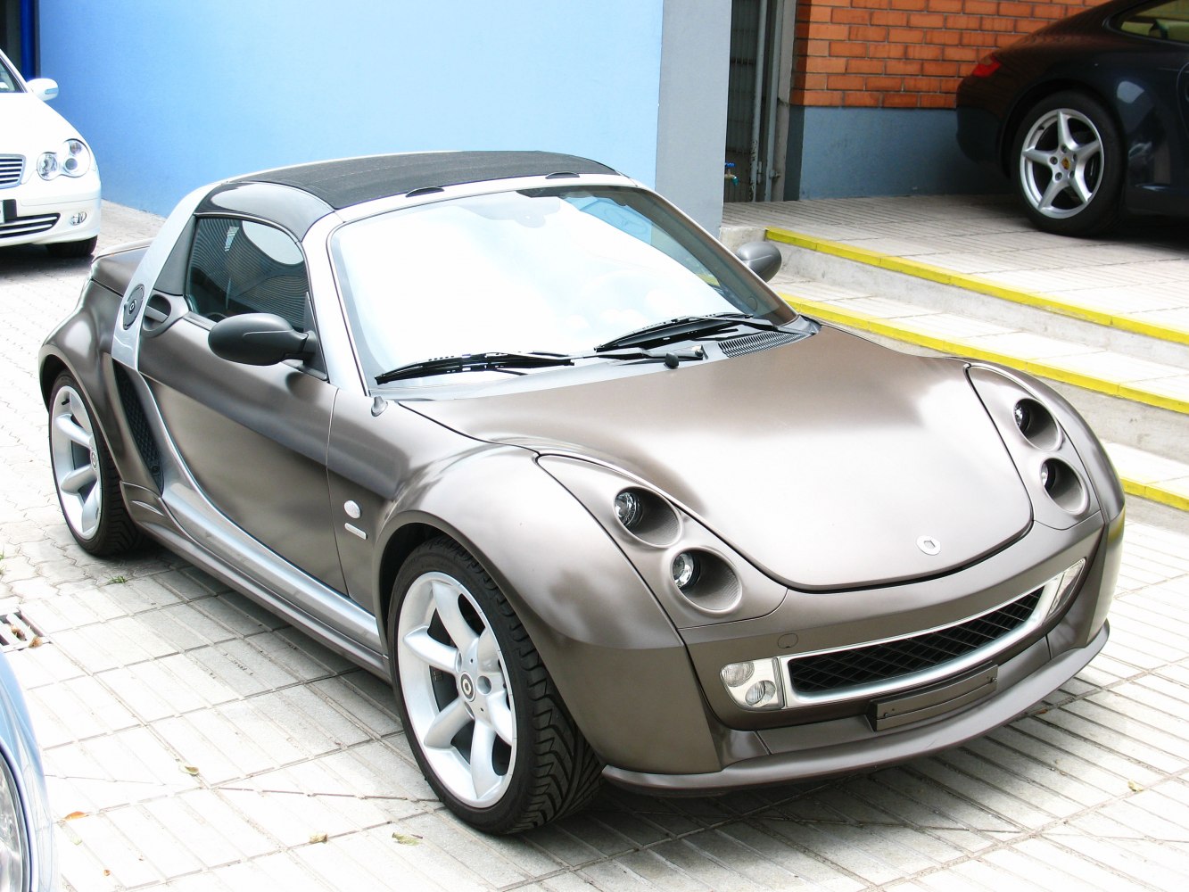 Front side view with distinctive dual round headlights and sporty compact design