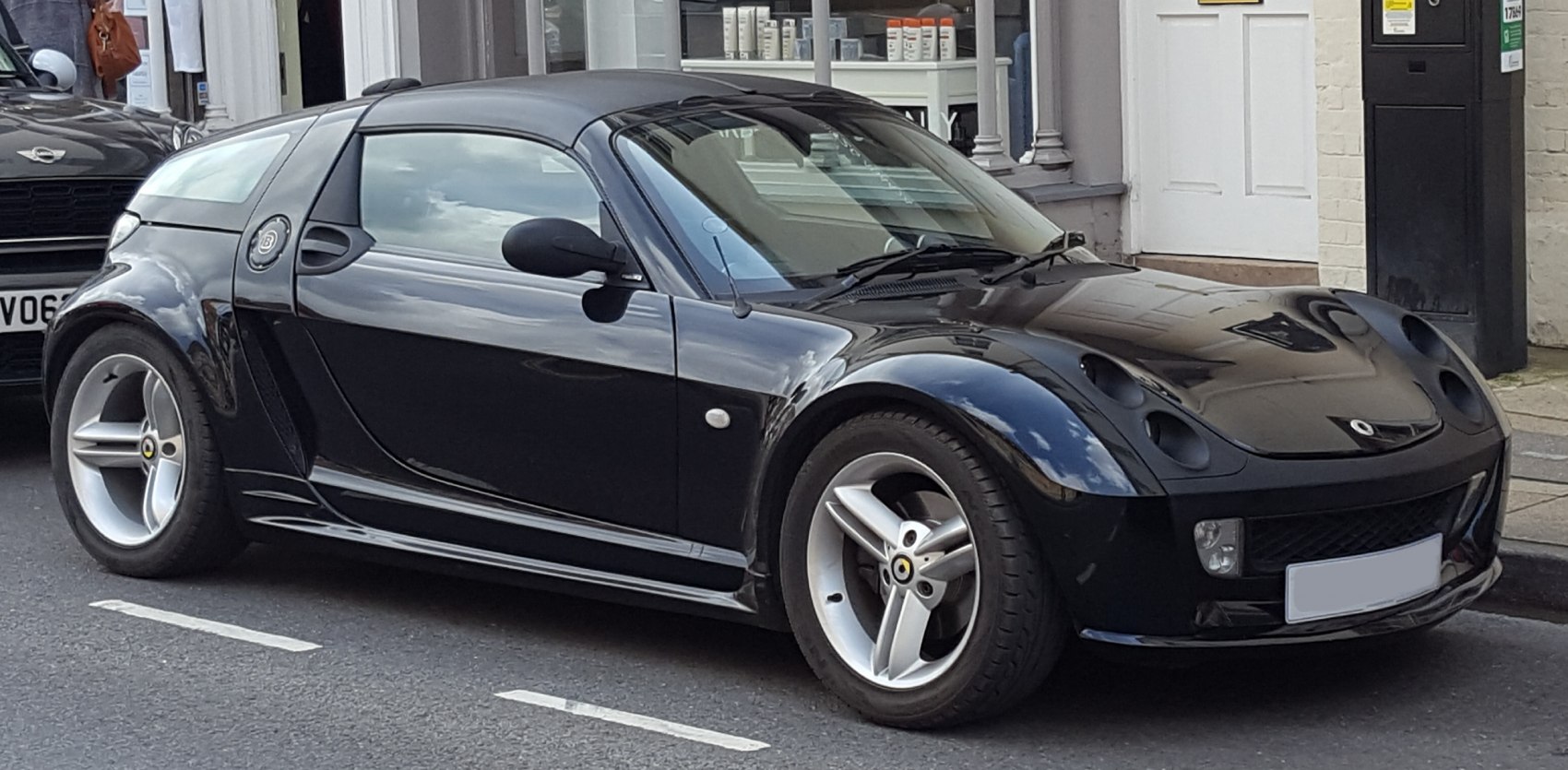 Black sports coupe with covered headlights and sleek aerodynamic body