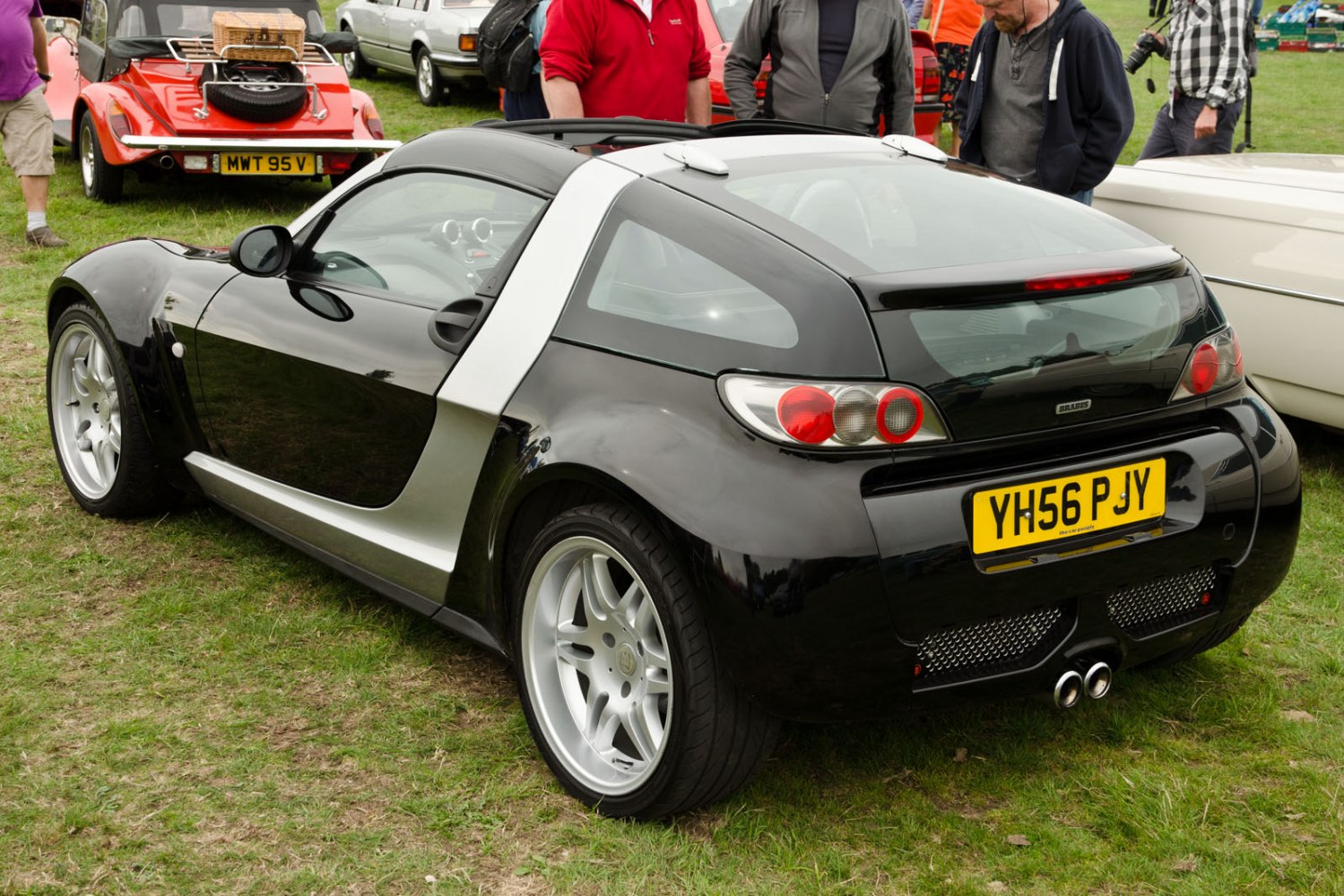 Compact sporty coupe with black body and dual exhaust pipes