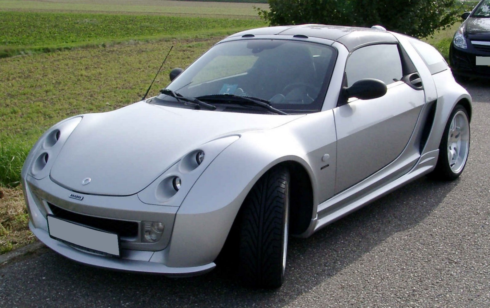 Compact two-seater roadster with quad headlights and sleek aerodynamic shape