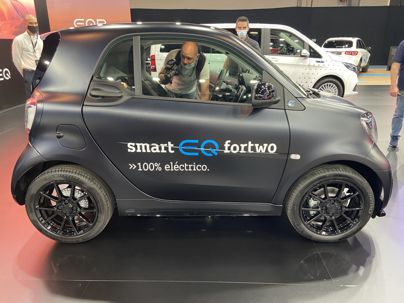 Compact two-door electric vehicle with black alloy wheels.