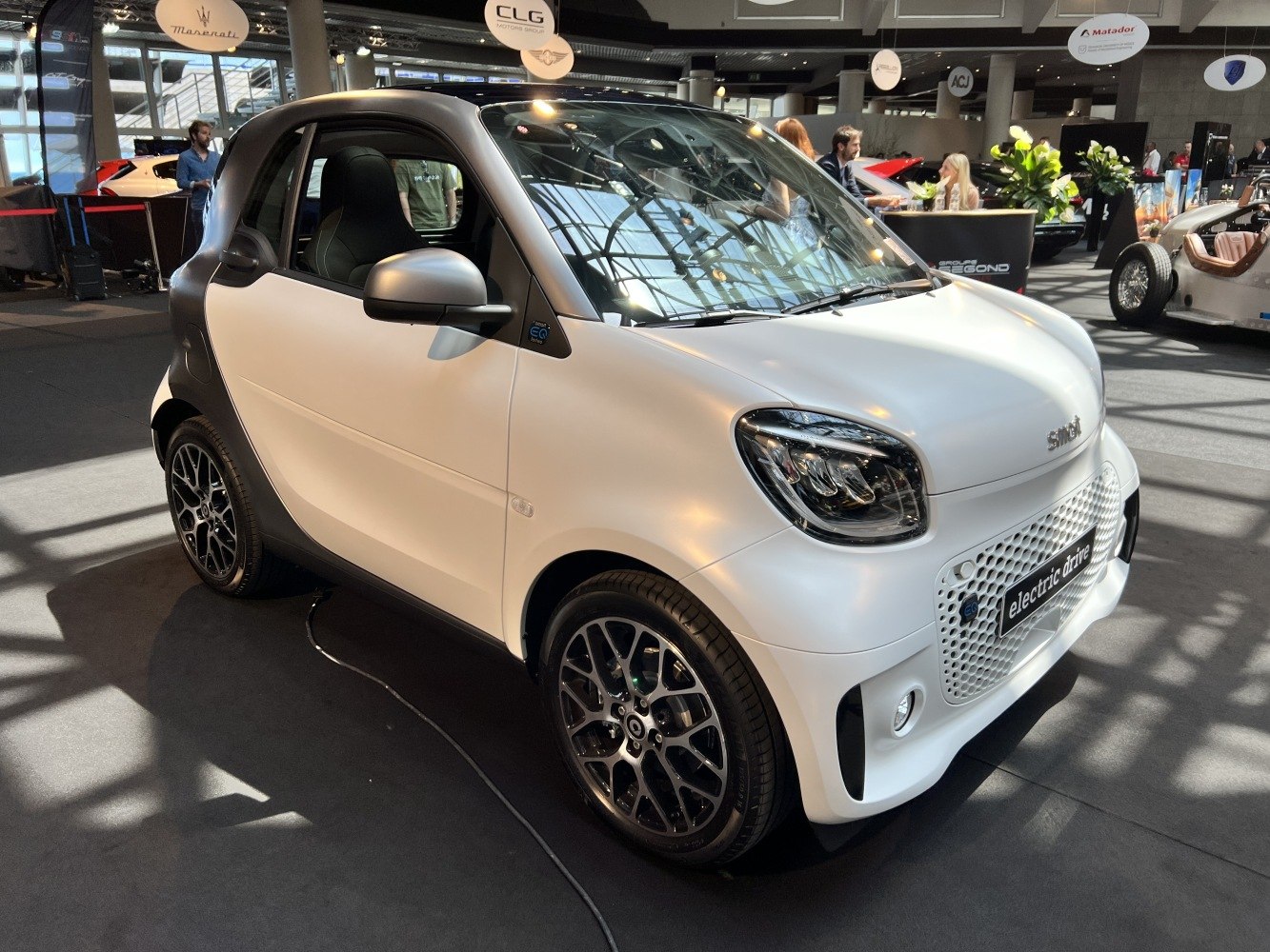 Front-side view of compact electric vehicle with modern grille and alloy wheels