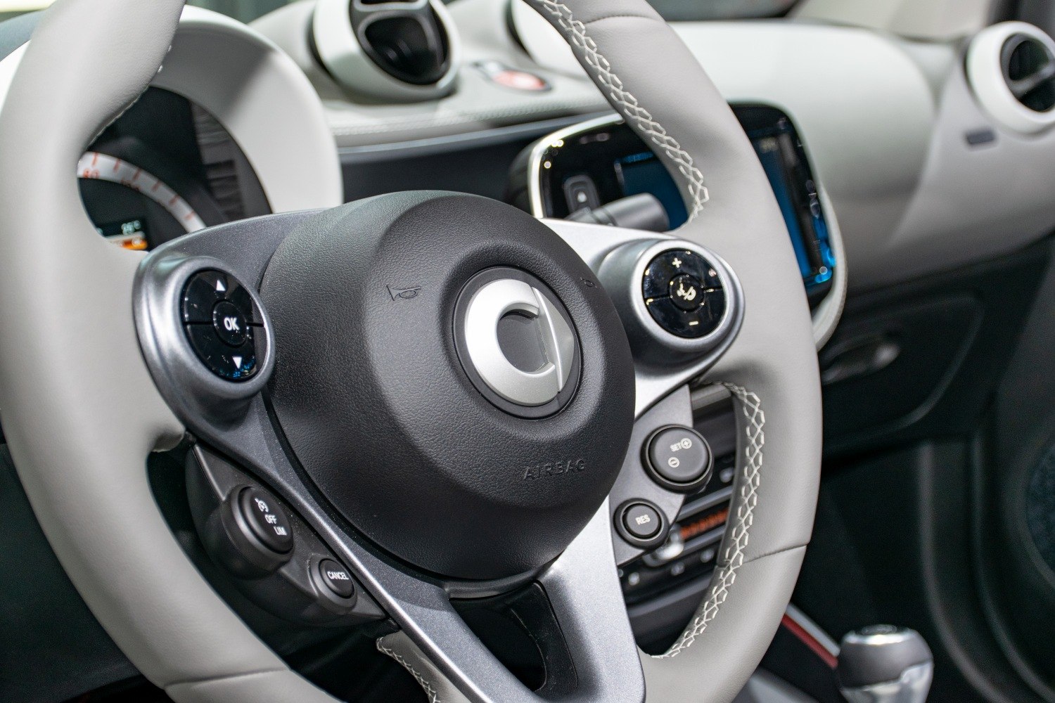 Close-up of steering wheel and dashboard controls in modern compact EV