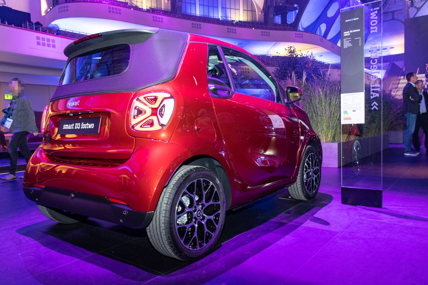 Rear view of compact electric convertible with distinctive LED taillights and soft-top roof