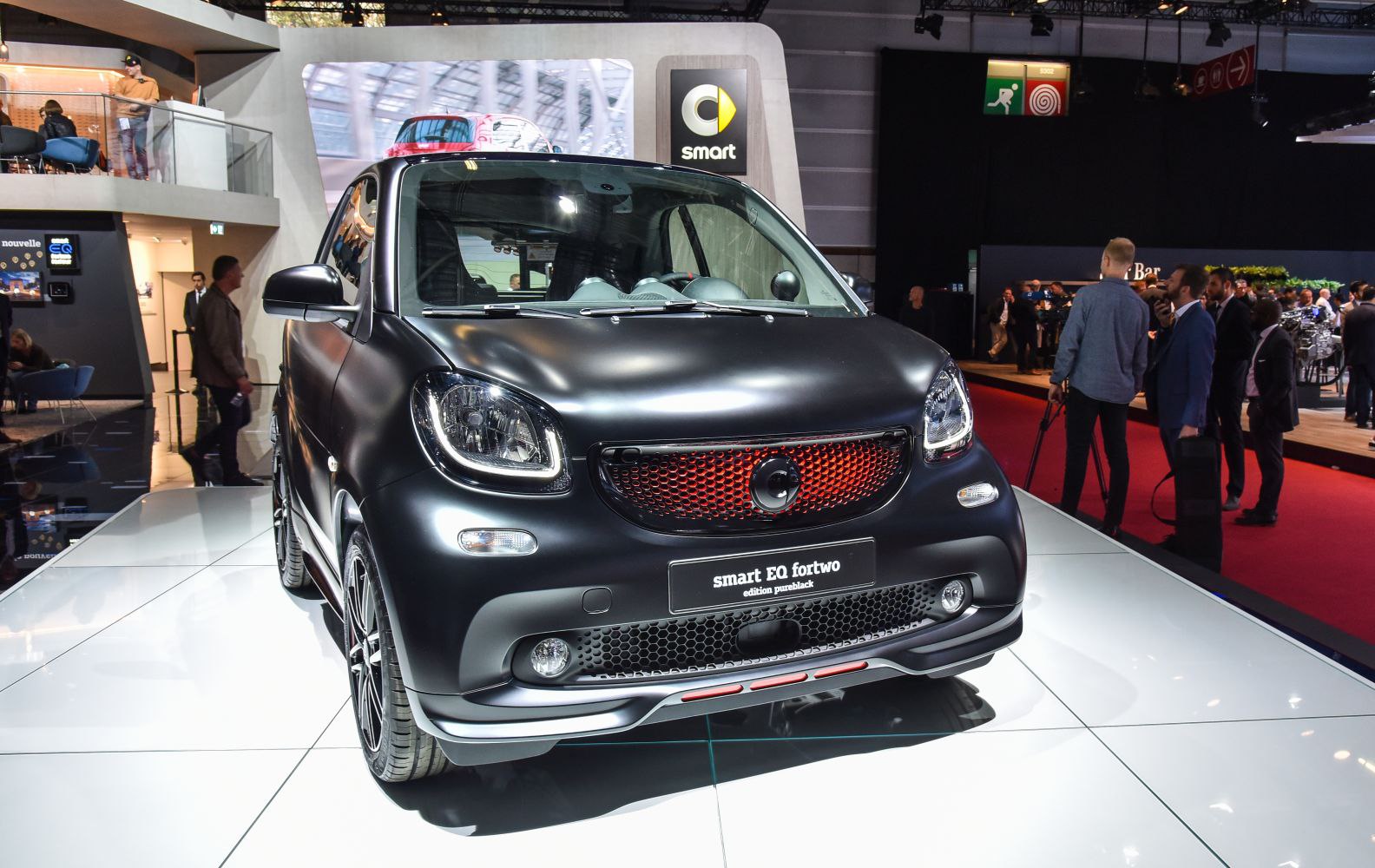 Front view of compact hatchback with black matte finish and red-accented grille