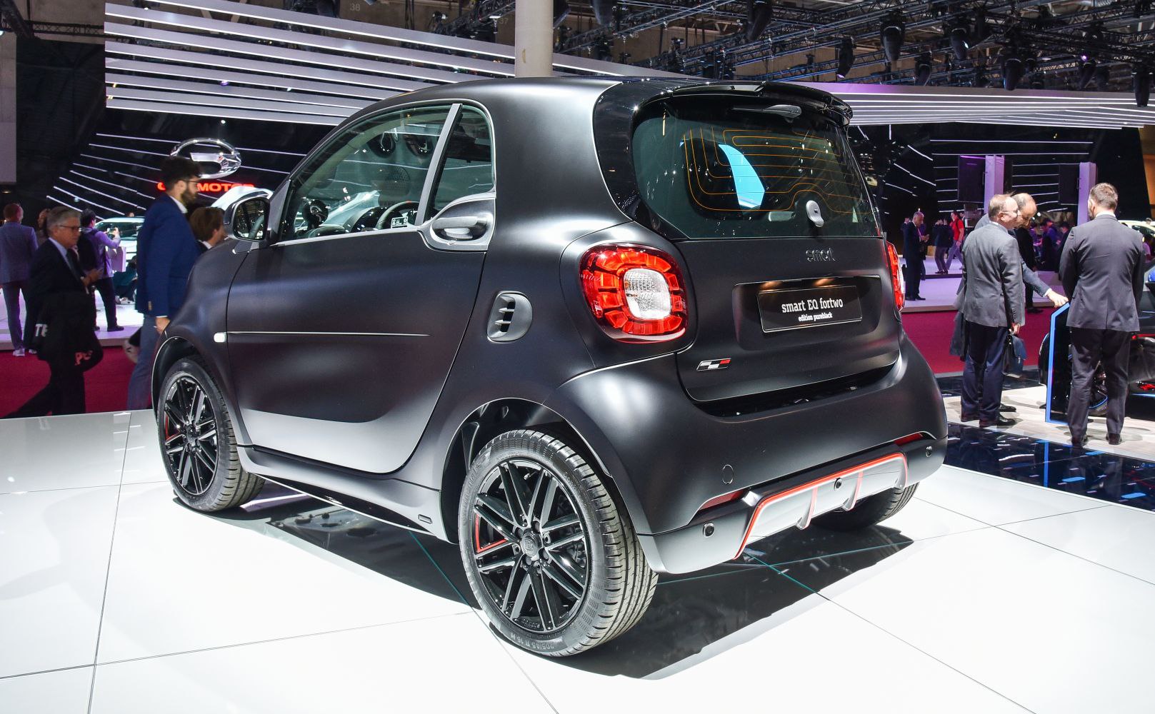 Rear side view of compact car with black alloy wheels and matte finish