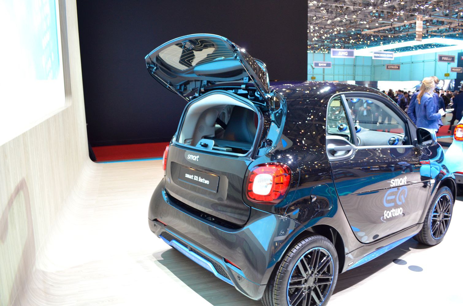 Rear view of compact electric hatchback with open trunk and distinctive taillights