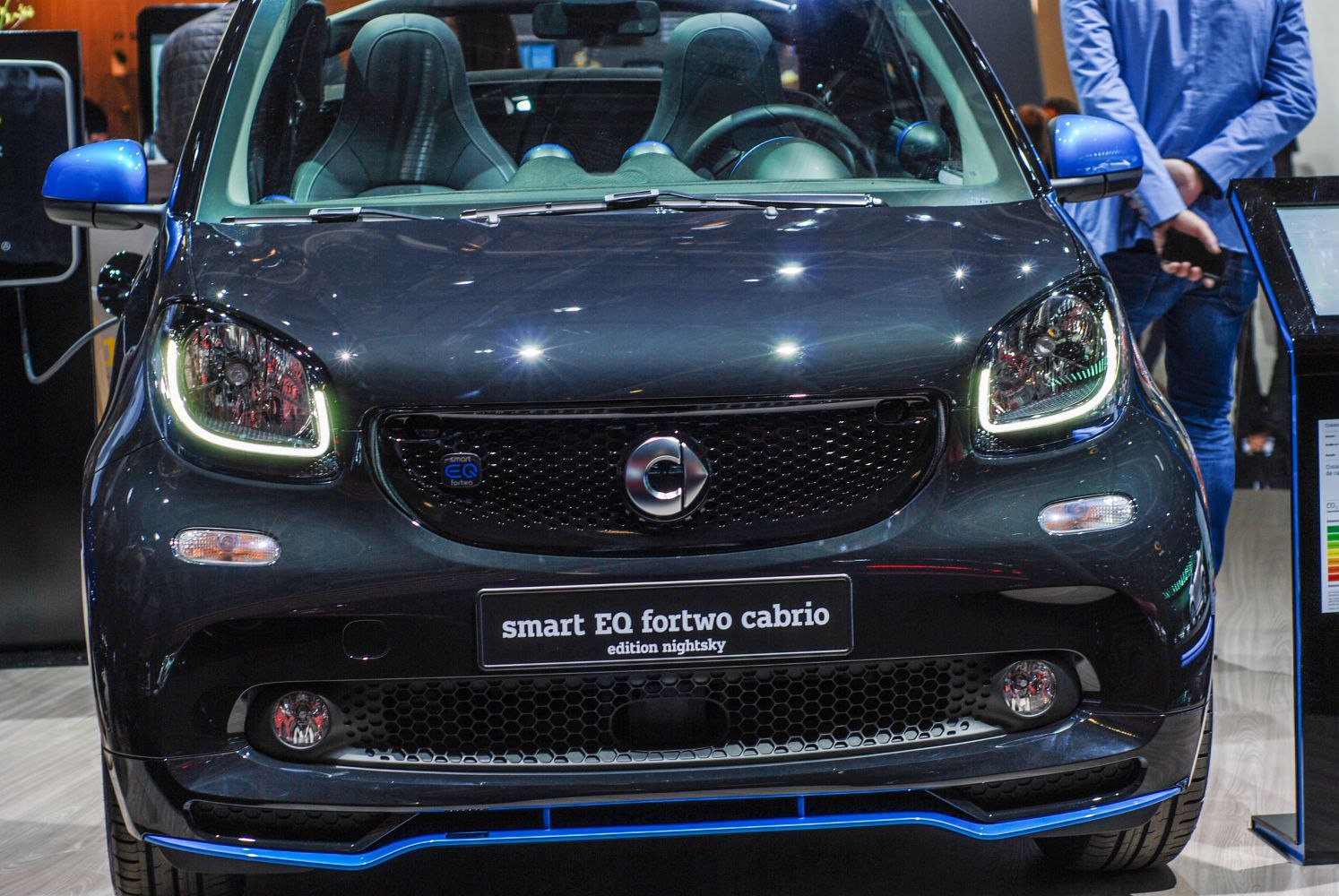 Front view of compact electric car with LED headlights and distinctive grille