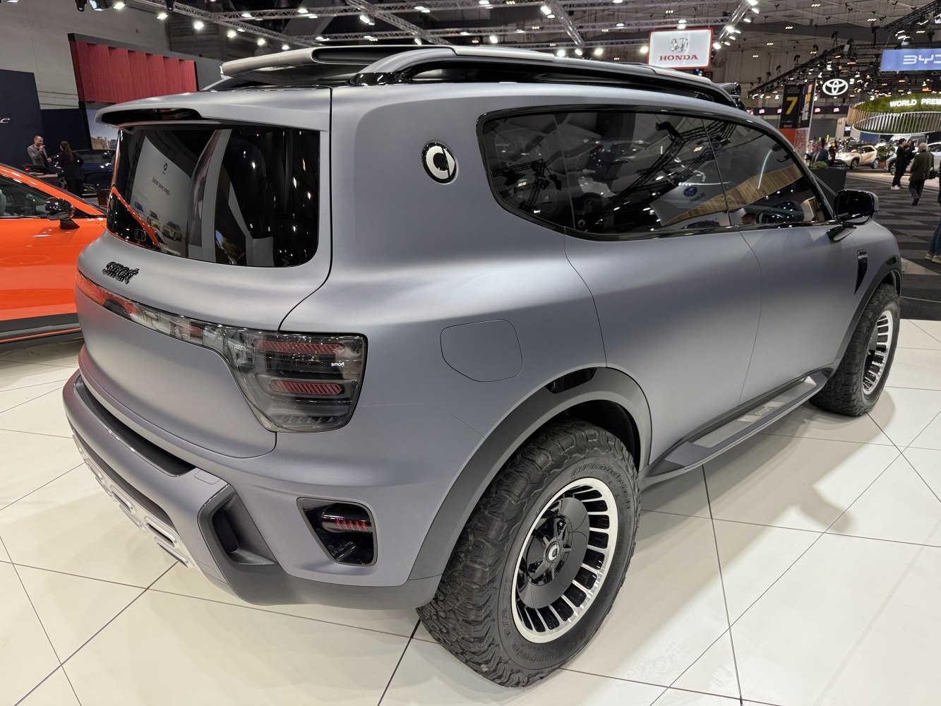 Matte grey electric SUV with tinted rear windows and rugged off-road tires