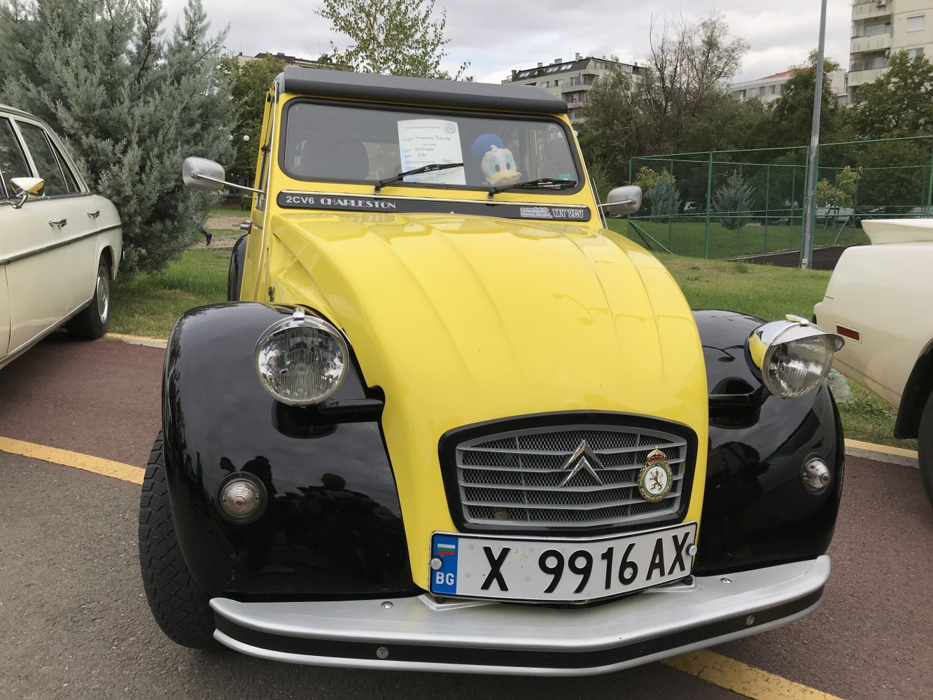 Vintage yellow and black car front with round headlights and grille