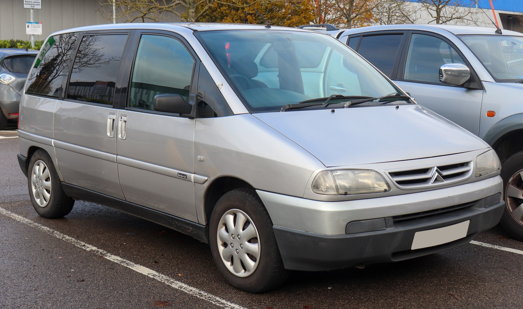 Front side view of a mid-1990s MPV with sliding doors and distinctive headlights