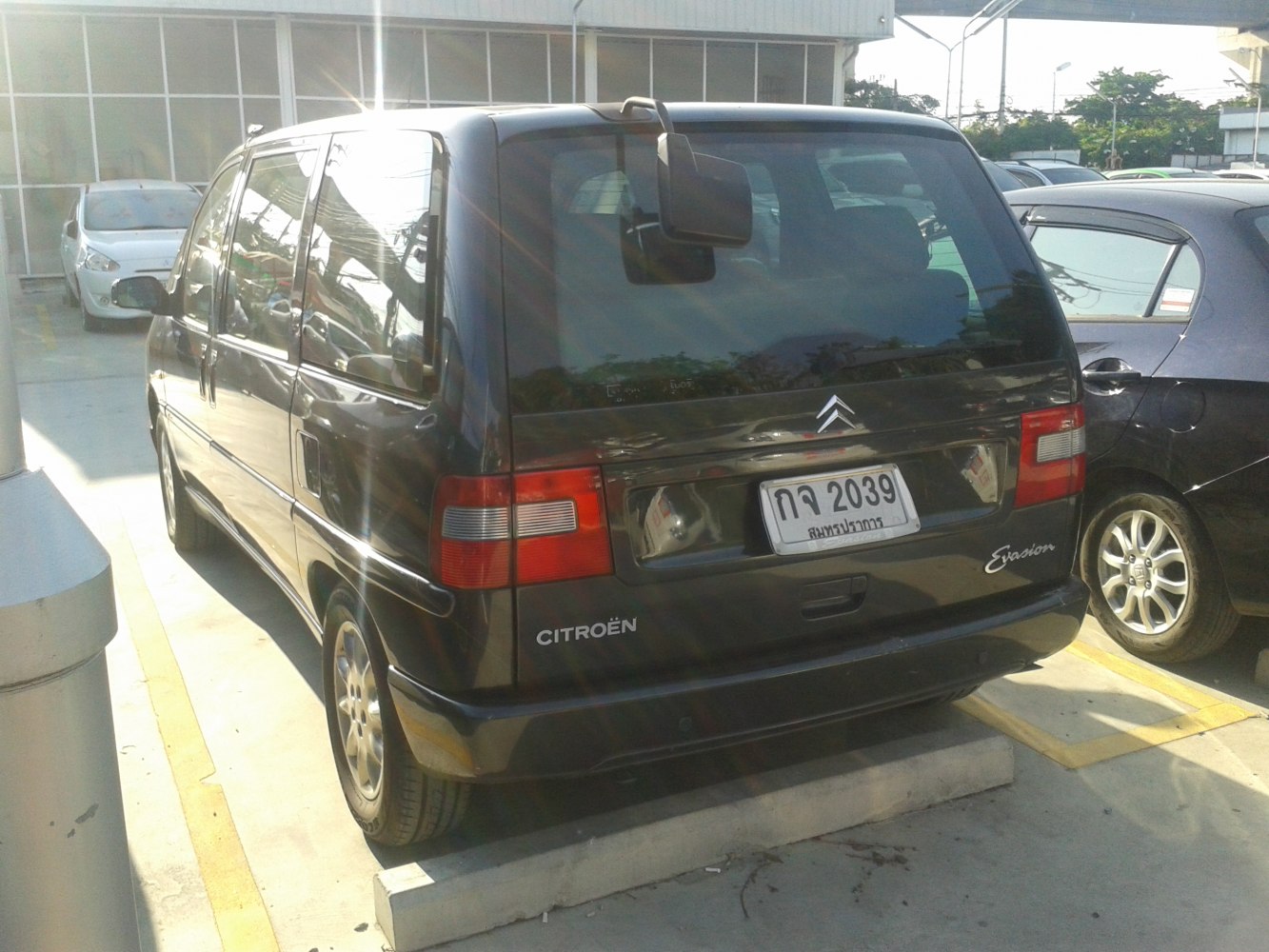 Rear view of black minivan with distinct taillights and rear window