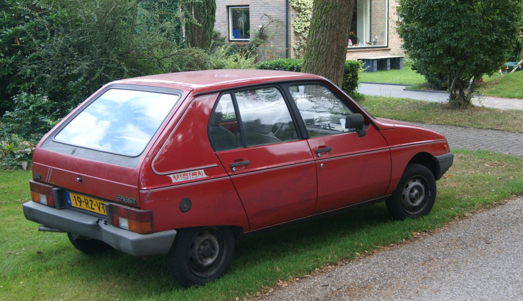 Rear side view of a compact vintage hatchback with boxy design.