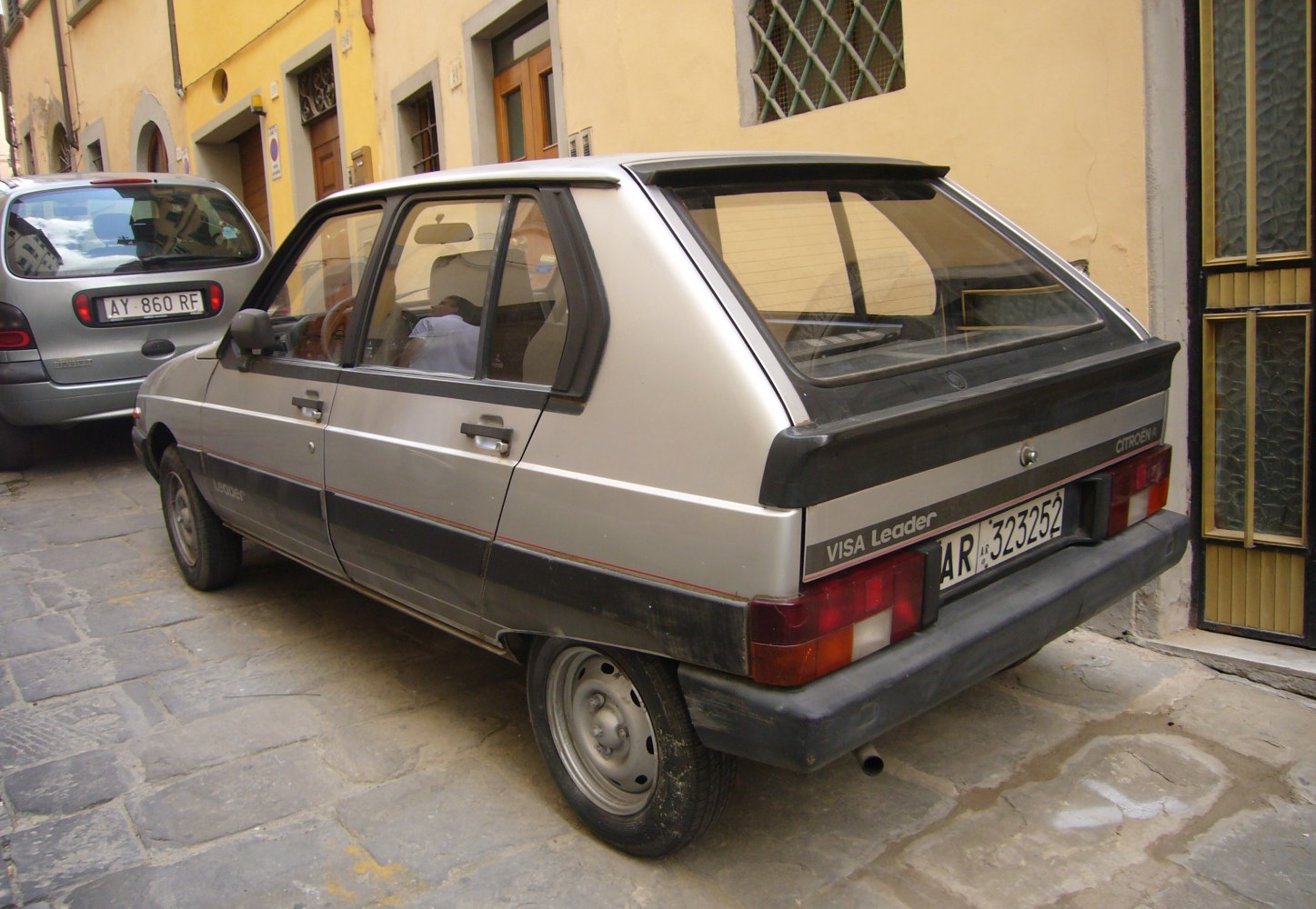Silver vintage hatchback rear and side view with rear spoiler.