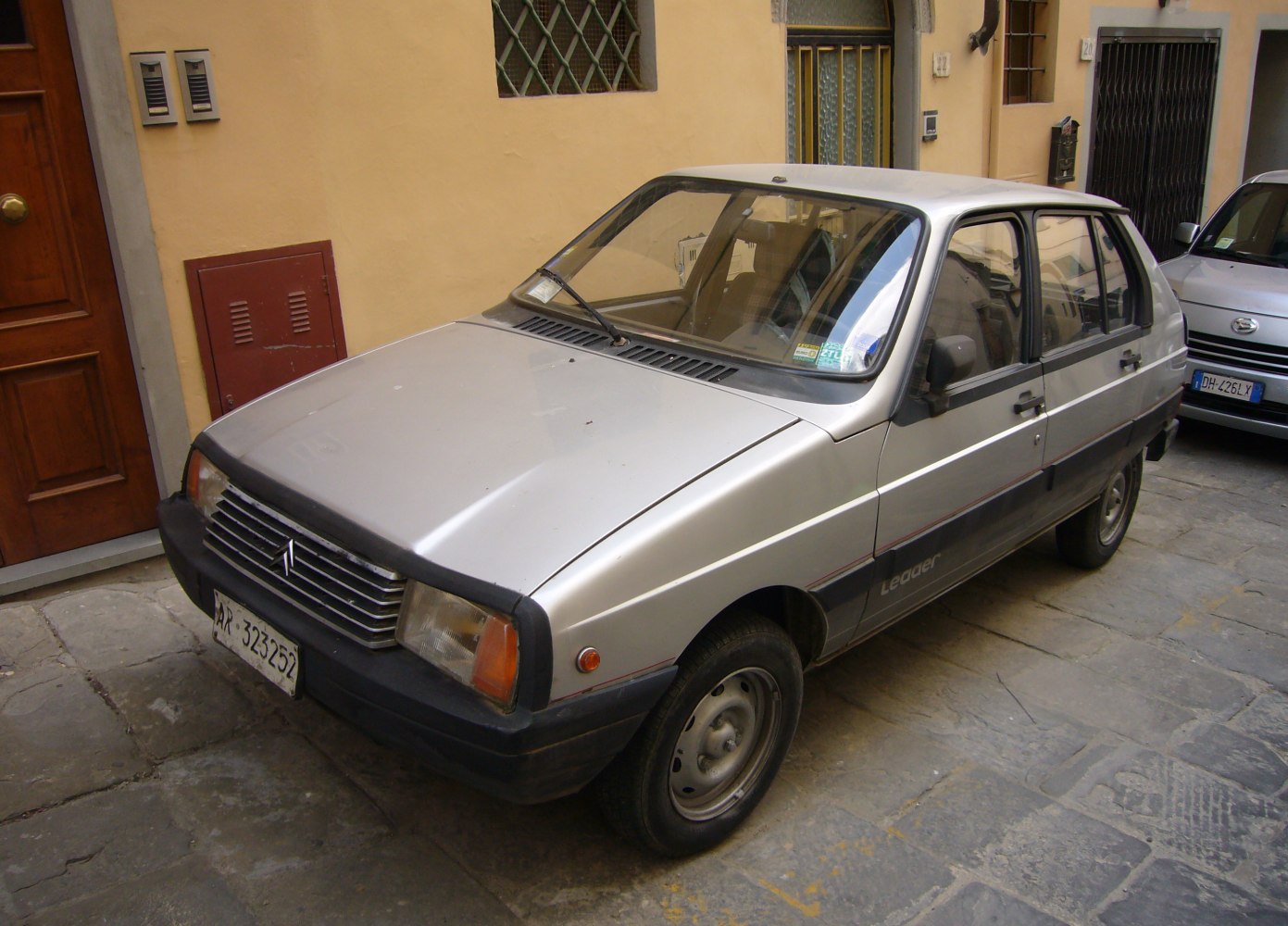 Silver vintage compact hatchback with black bumper and trim front-left angle