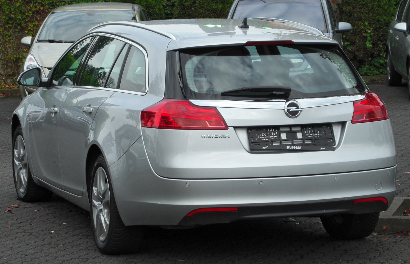 Rear view of silver station wagon with distinct taillights and roof rails