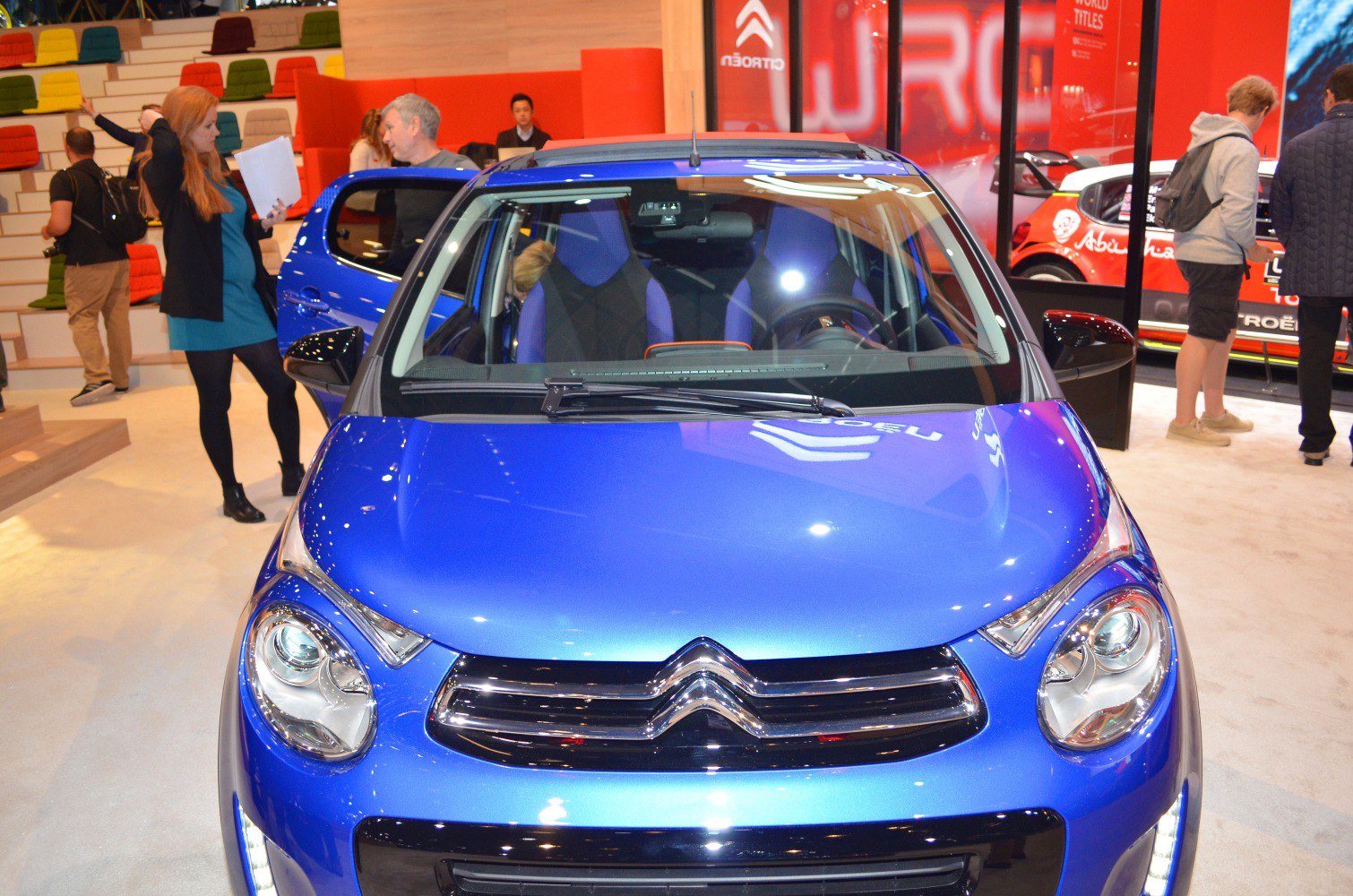 Front view of blue compact hatchback with distinctive headlights and chrome grille