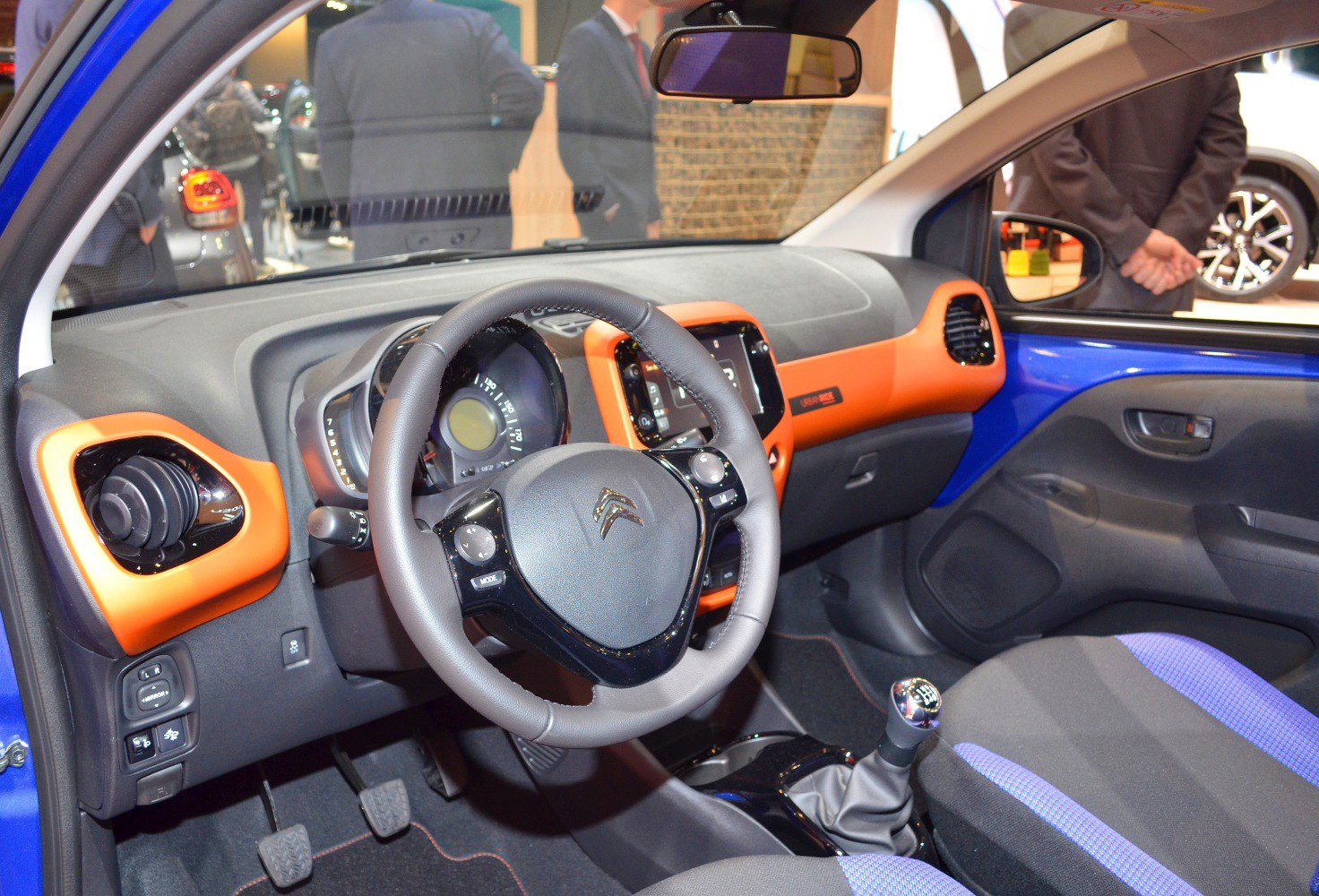 Car interior with orange dashboard trim and manual gear stick
