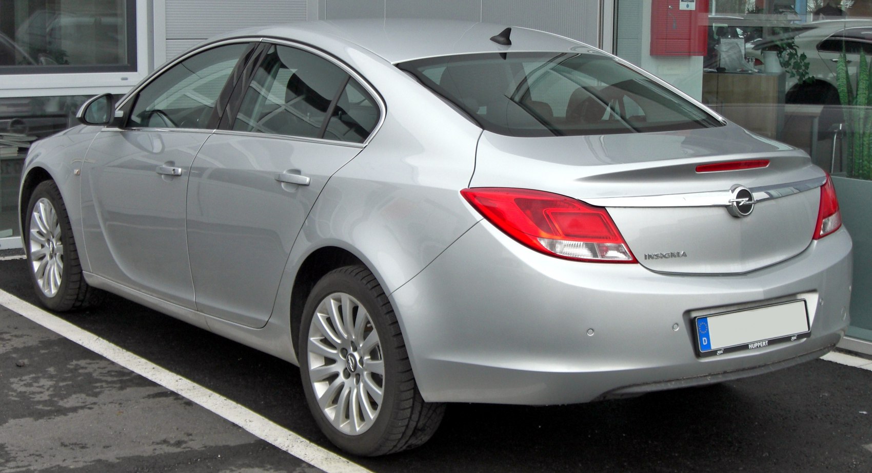 Silver executive sedan rear with distinctive tail lights and sleek design
