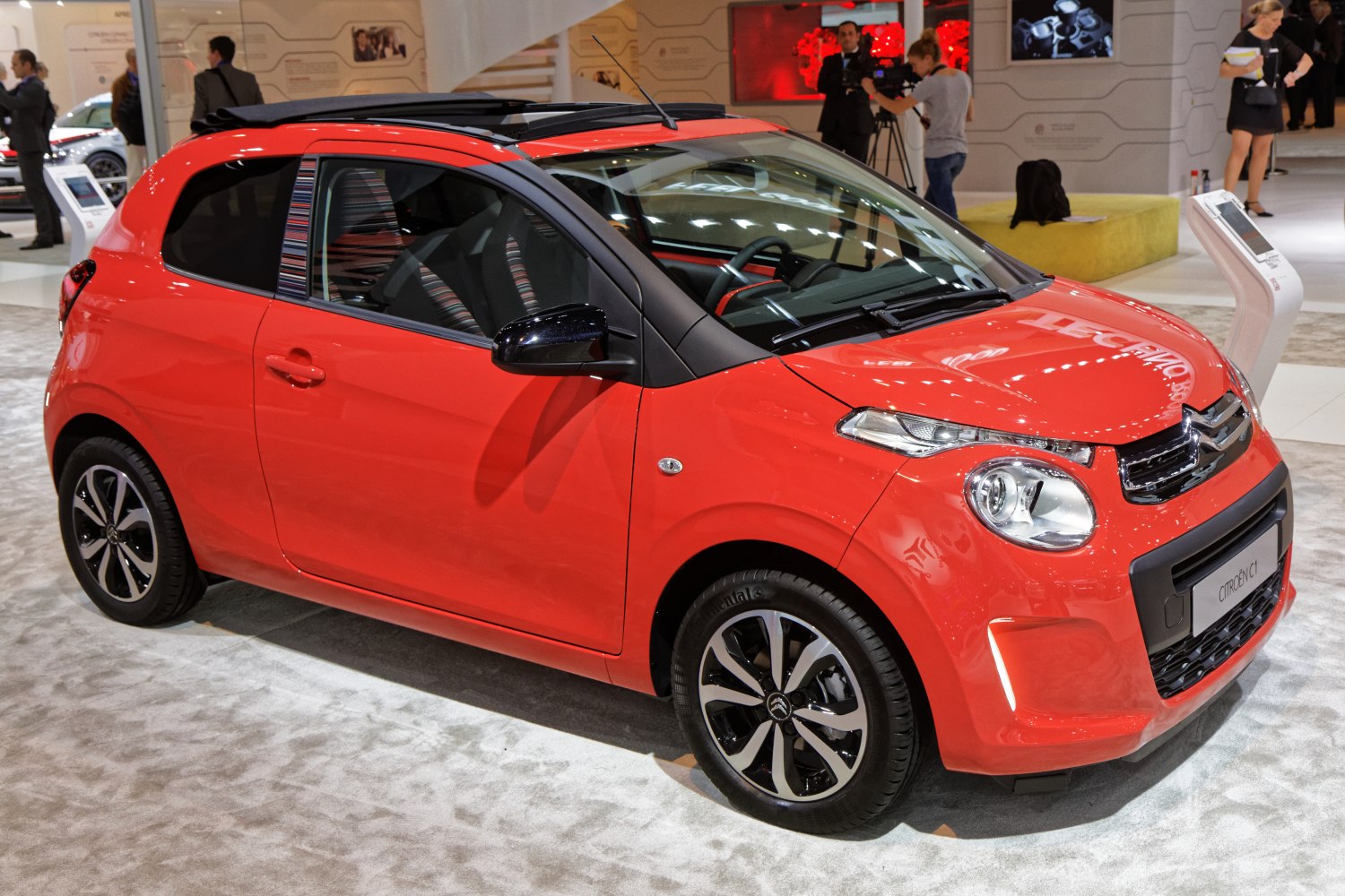 Red compact hatchback with panoramic open roof and alloy wheels