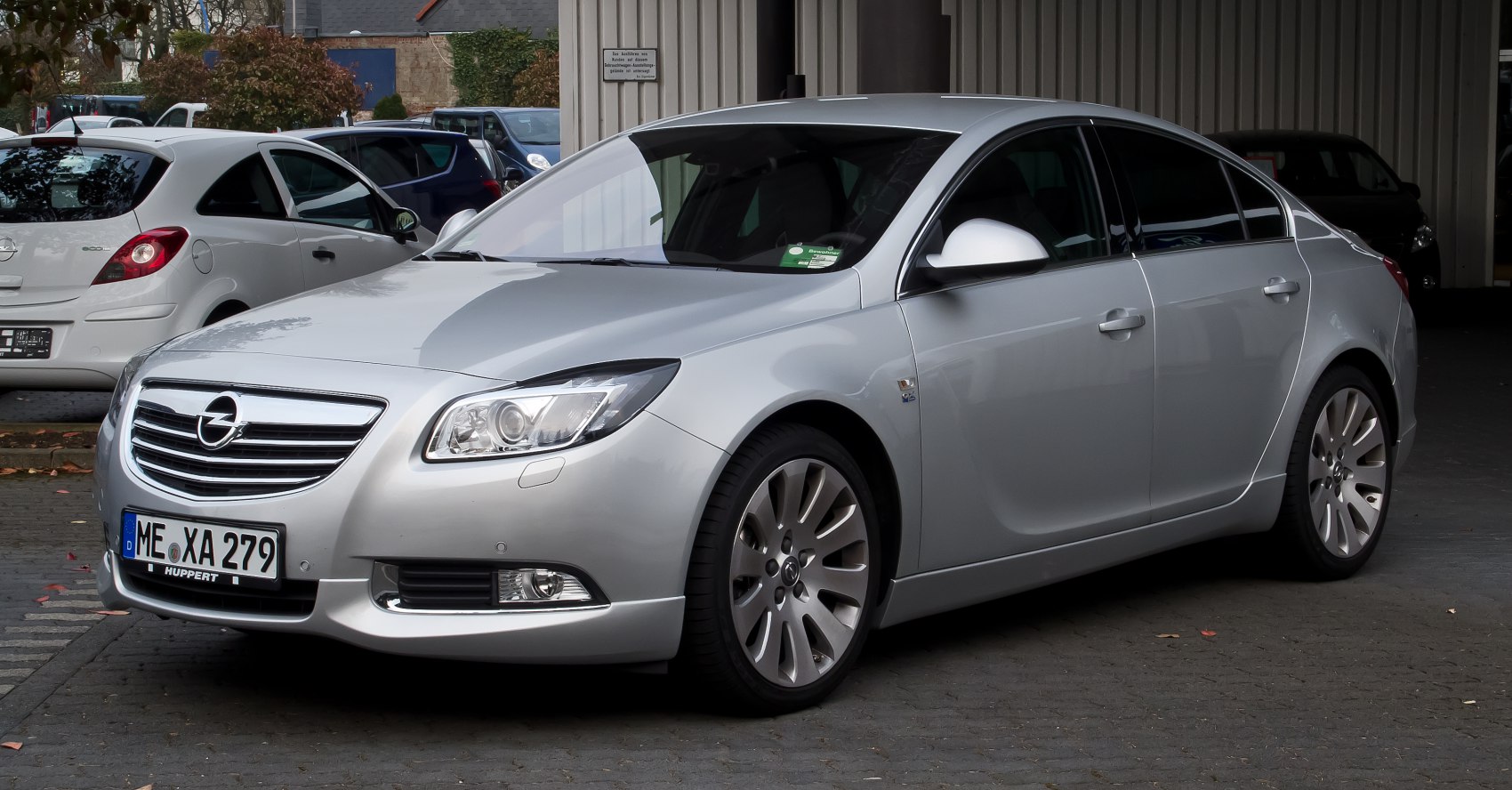 Front side view of silver sedan with sleek headlights and alloy wheels