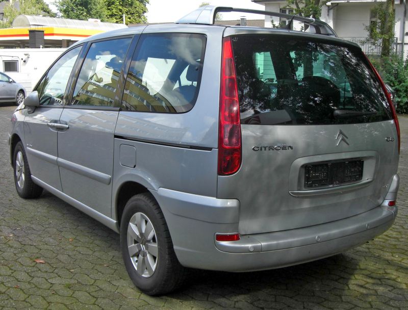 Rear view of silver minivan with vertical tail lights and large rear window