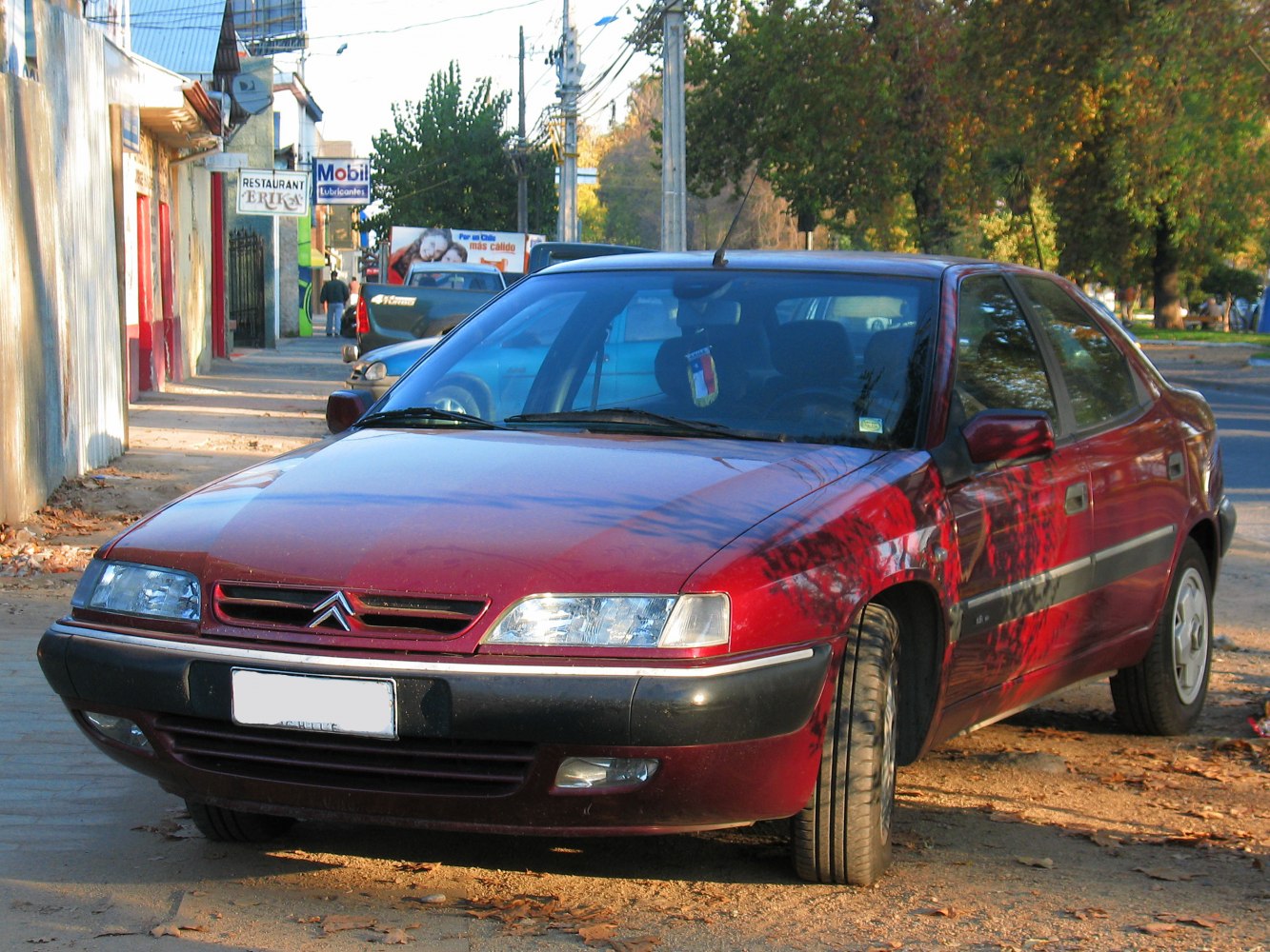 Front and side exterior of a mid-90s sedan in urban street setup
