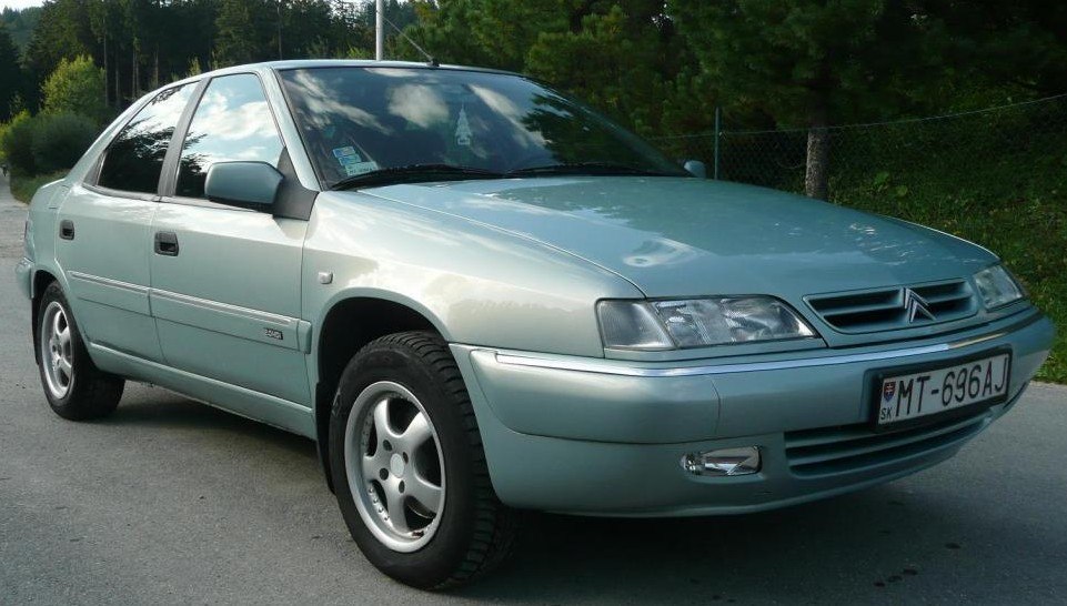 Front side profile of classic 90s sedan with distinctive headlights and smooth lines