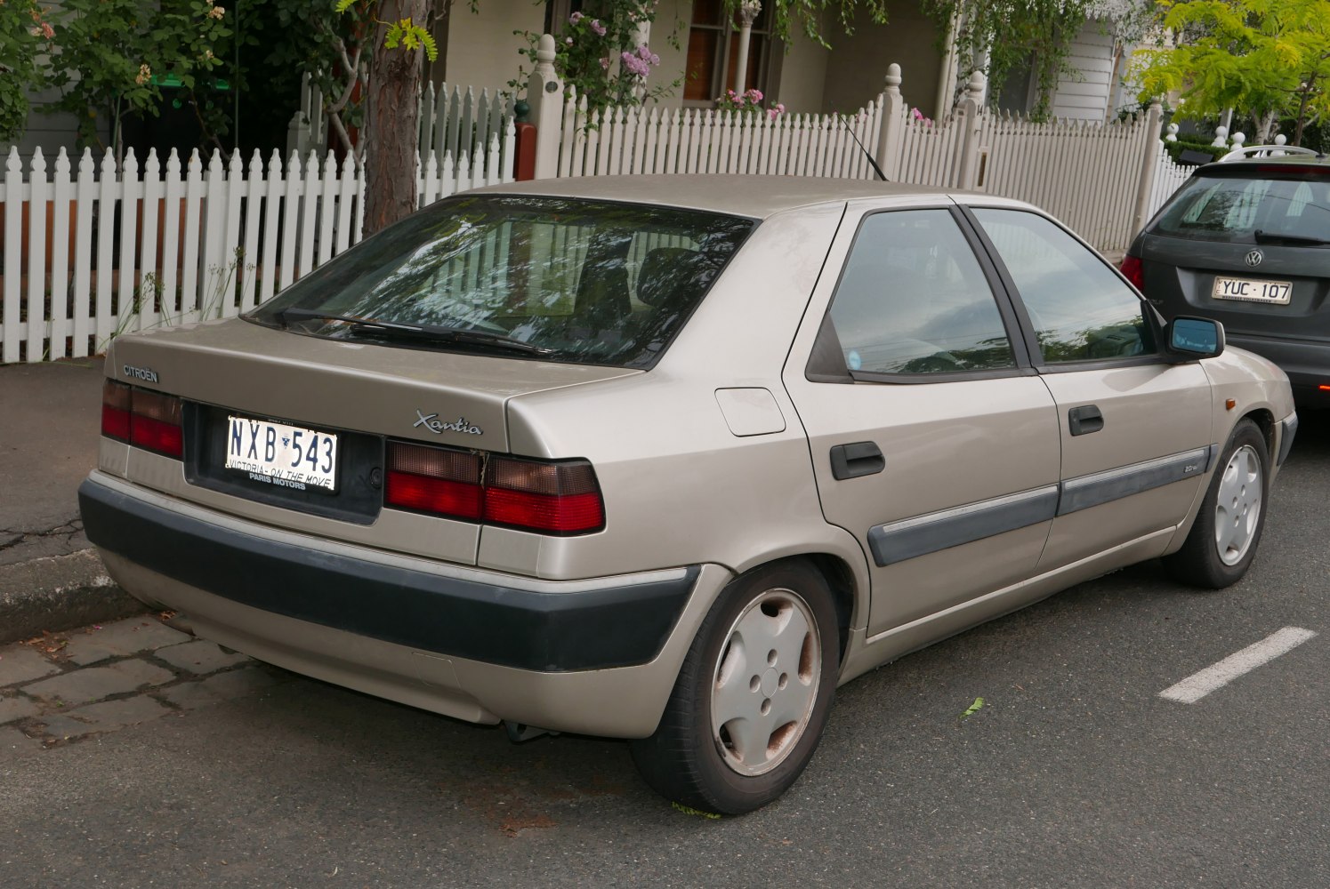 Side and rear view of hatchback with black bumper and distinctive wheel covers